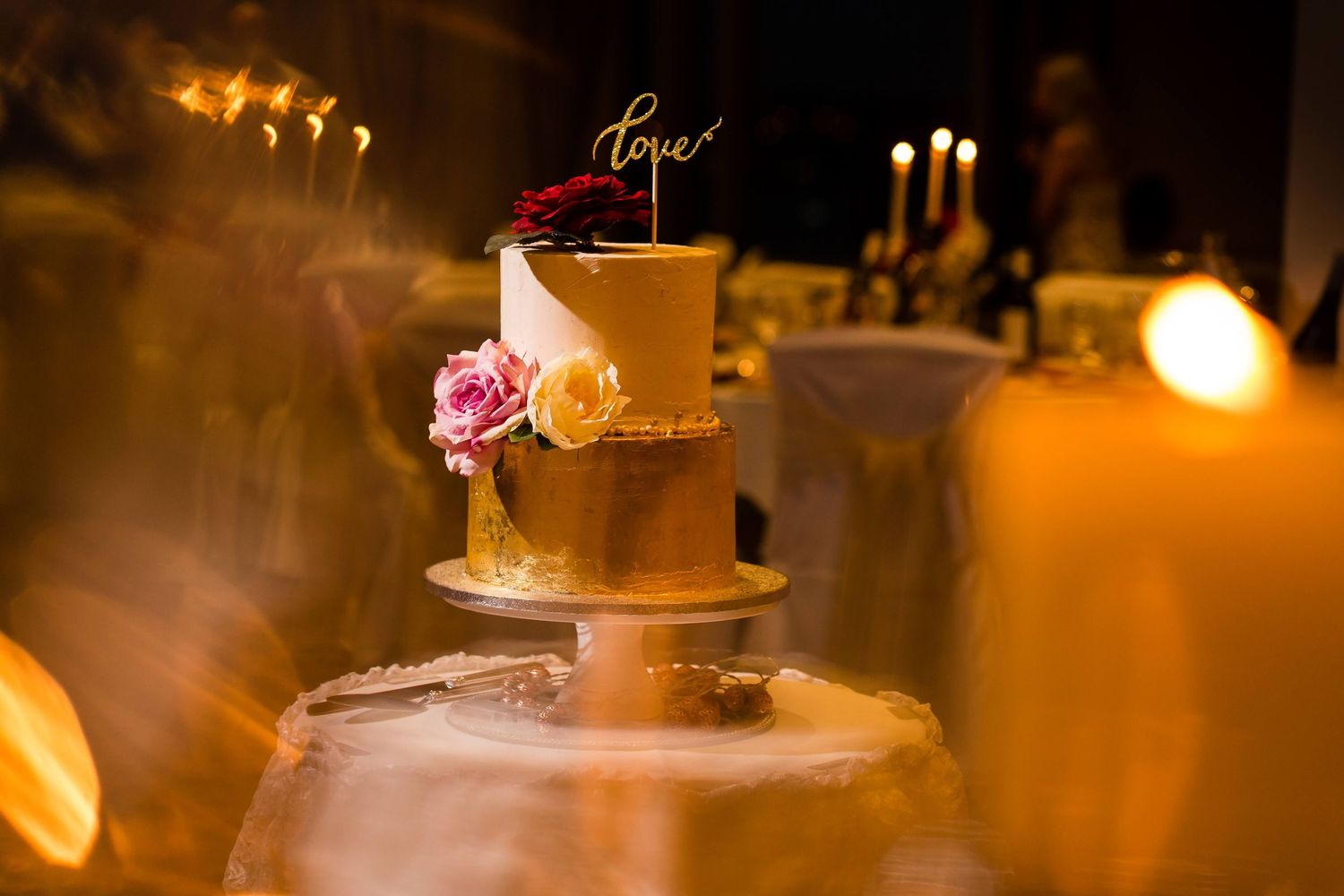 Romantic candlelit wedding reception table setting with glowing candles and elegant floral centerpieces.