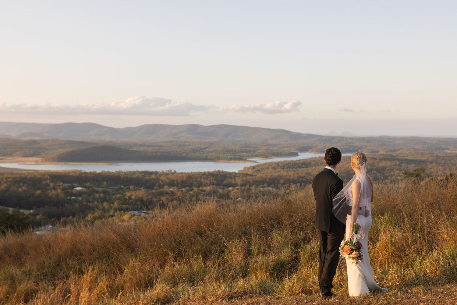 A scenic mountain landscape panorama at sunset with rolling hills and distant peaks stretching across the horizon.