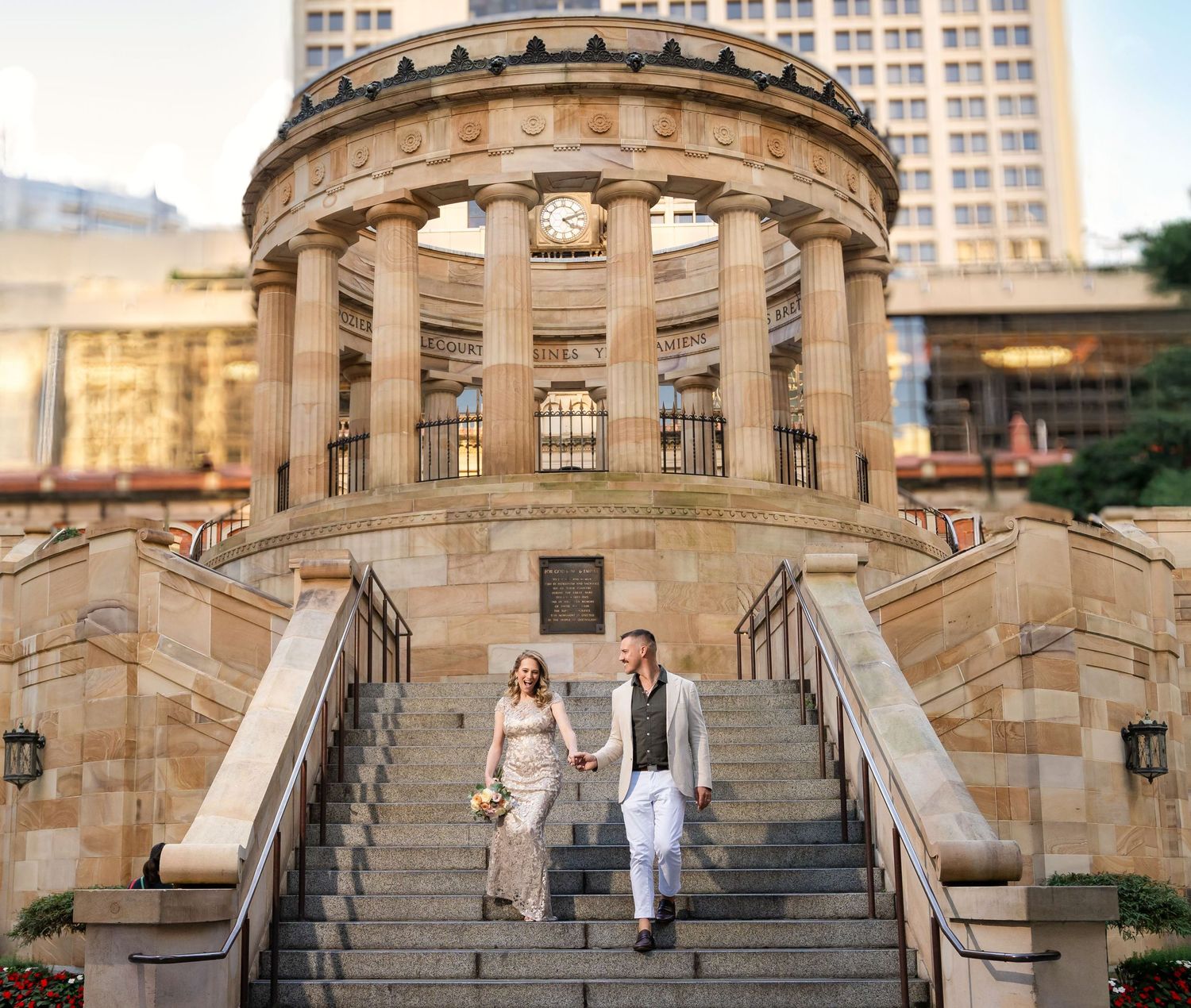 A couple poses on the grand stone staircase at the historic Merchant's Exchange Building in Philadelphia.