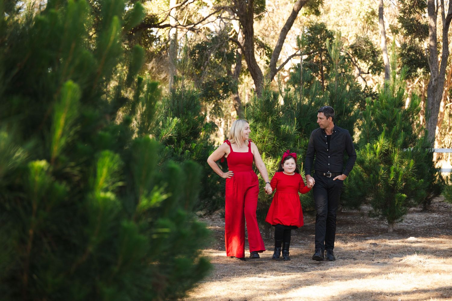 Five consecutive views of a walkway through a wooded park area with figures in red clothing visible in the distance.