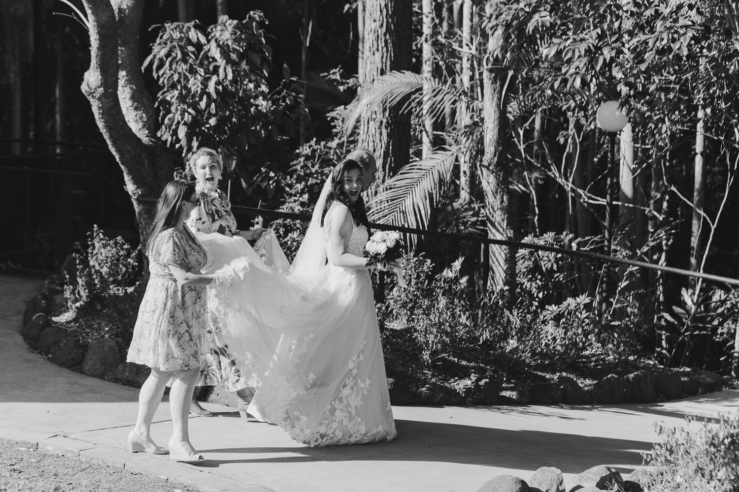 A joyful wedding party dances and celebrates together on an outdoor dance floor during a reception celebration.