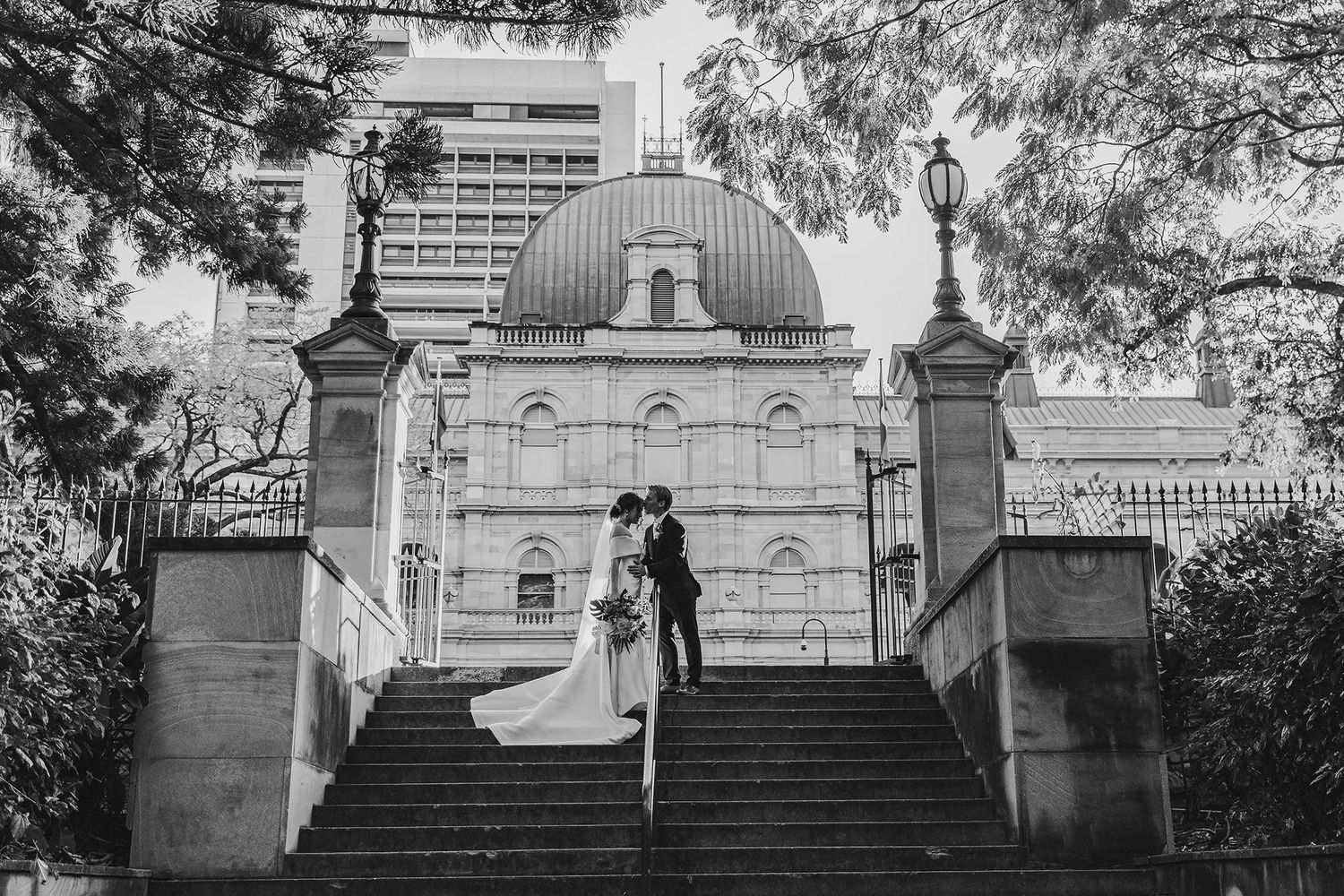 Classic domed building with grand stone staircase and ornate architecture in black and white.