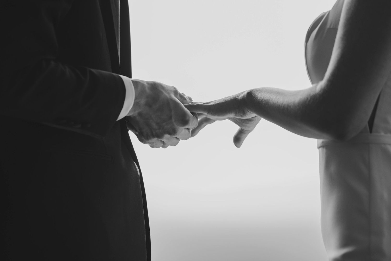 Black and white photograph of a person's hand reaching out against a blurred background.