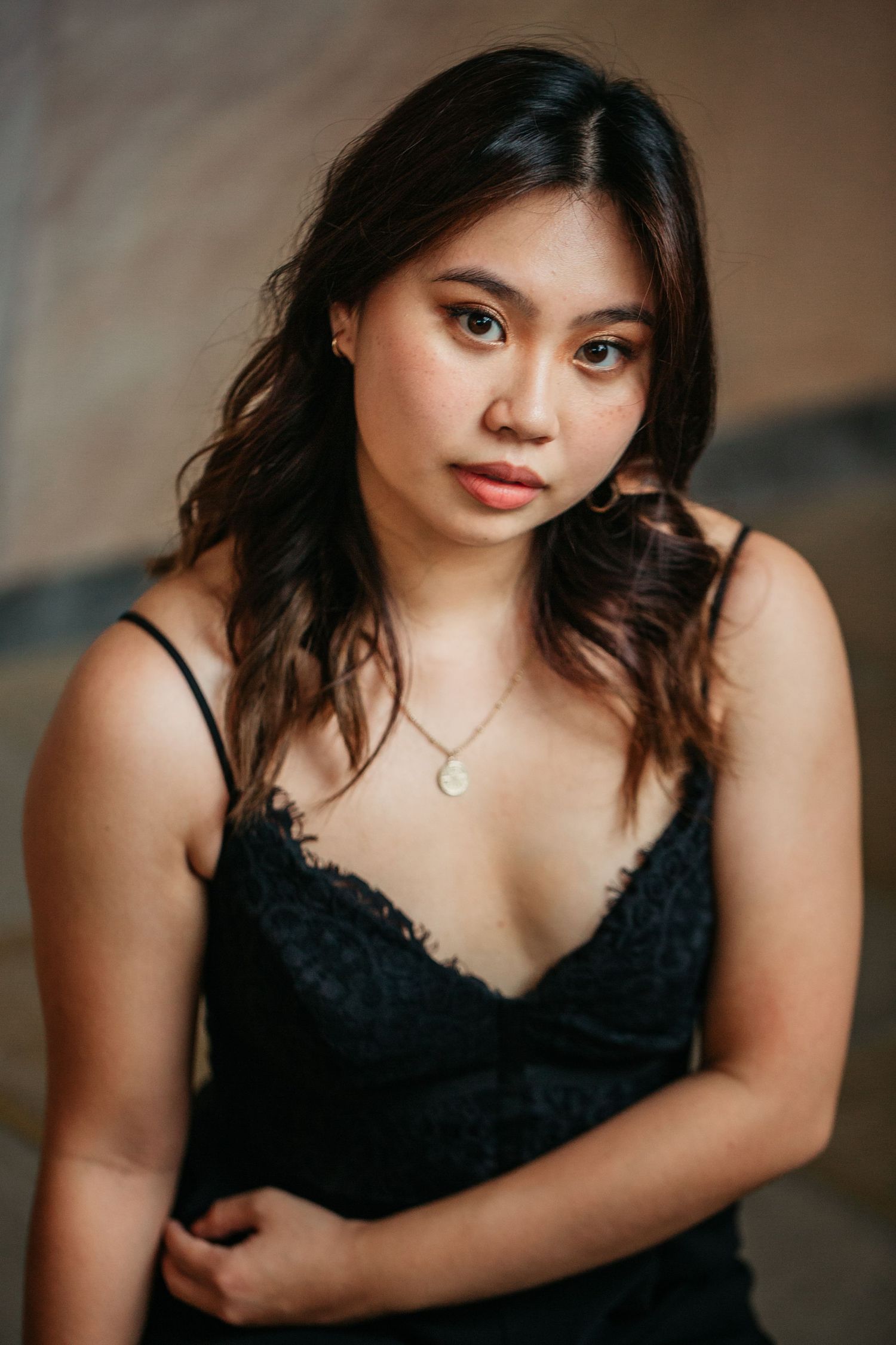 Portrait in black lace camisole with delicate necklace.