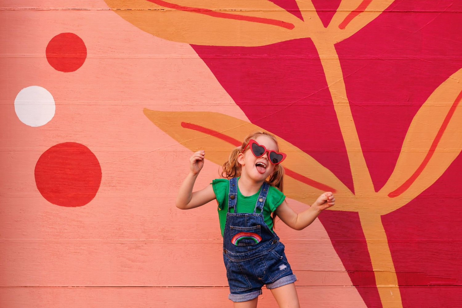Person dances and poses against vibrant red and orange wall with circular pattern design details.