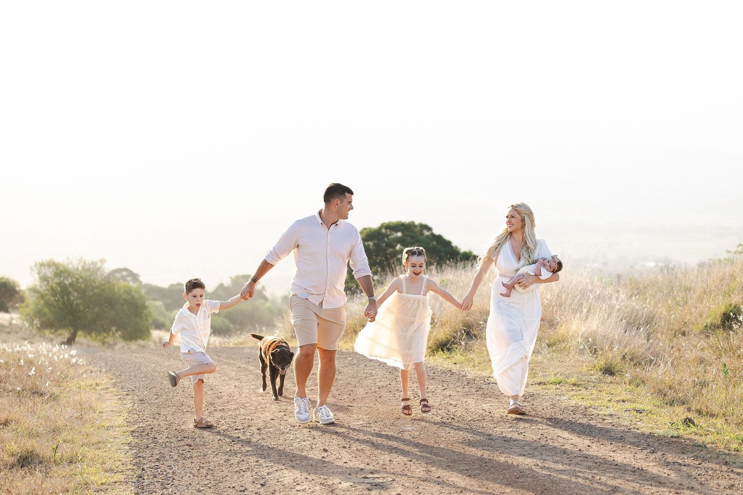 A collage of family photos showing people walking together in white outfits on a sunny beach path.
