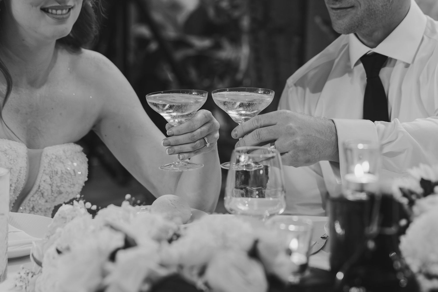 Wedding guests raise their glasses in a toast during an elegant reception dinner.