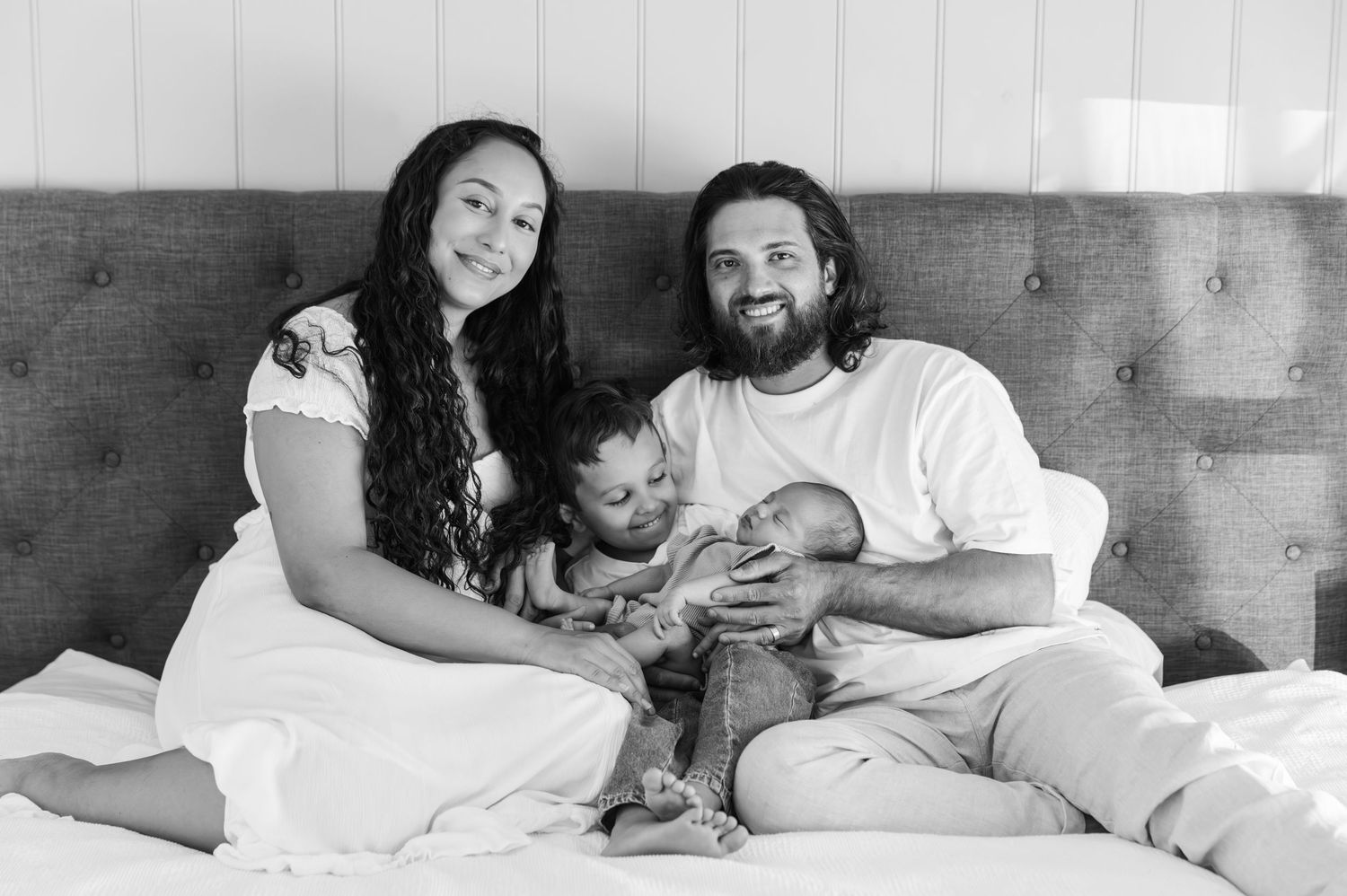 A black and white photo series showing a couple relaxing together on a bed in casual intimate moments.