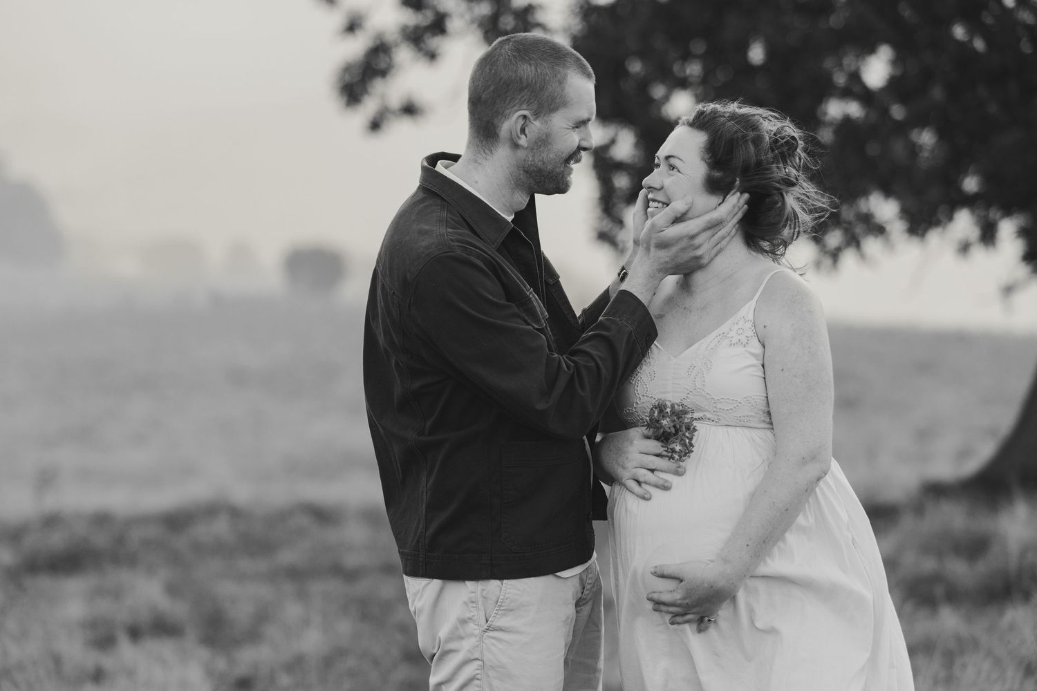 A couple shares a romantic kiss in an outdoor setting during their wedding photoshoot.