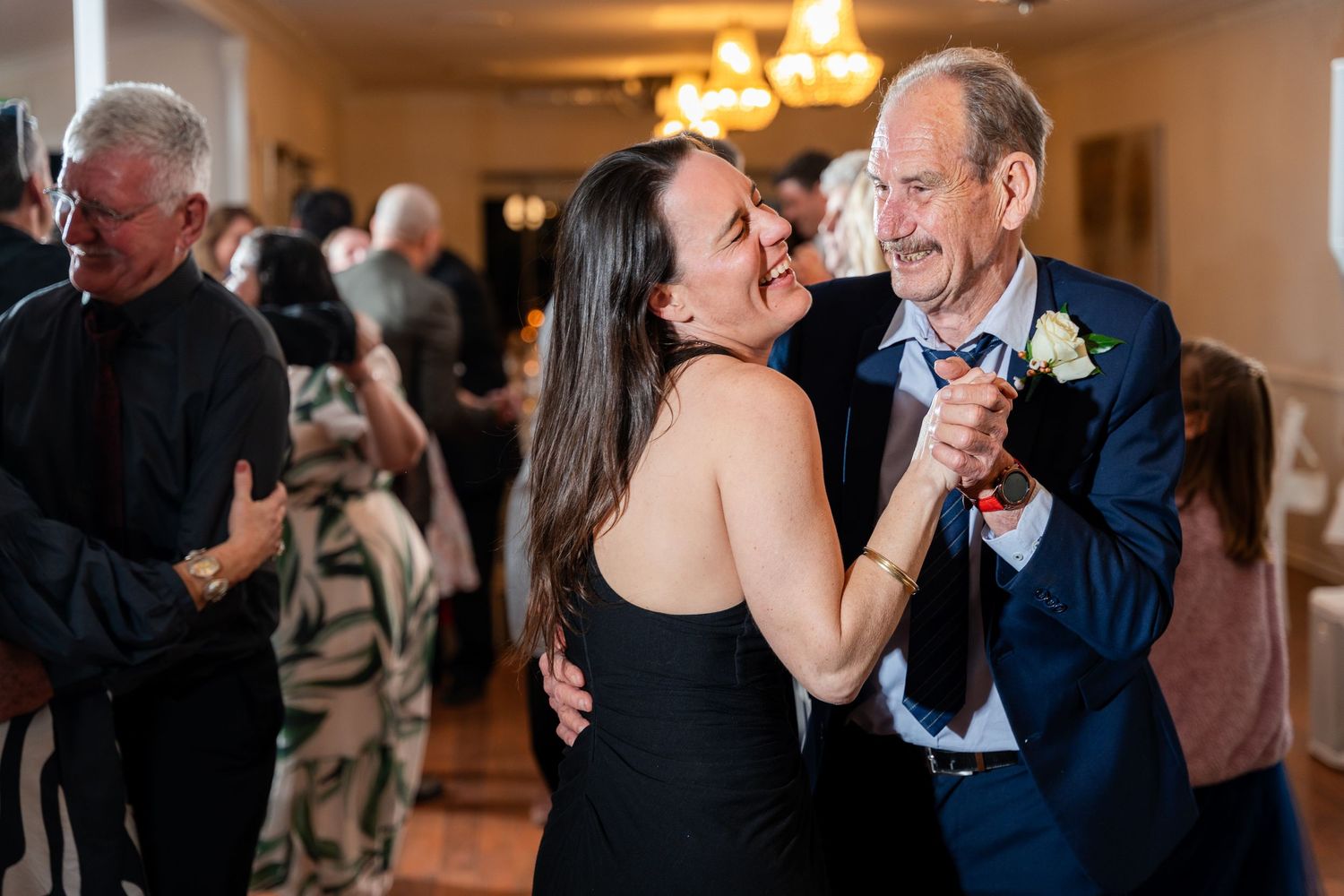 Couples dancing together during a romantic evening event in an elegant ballroom setting.