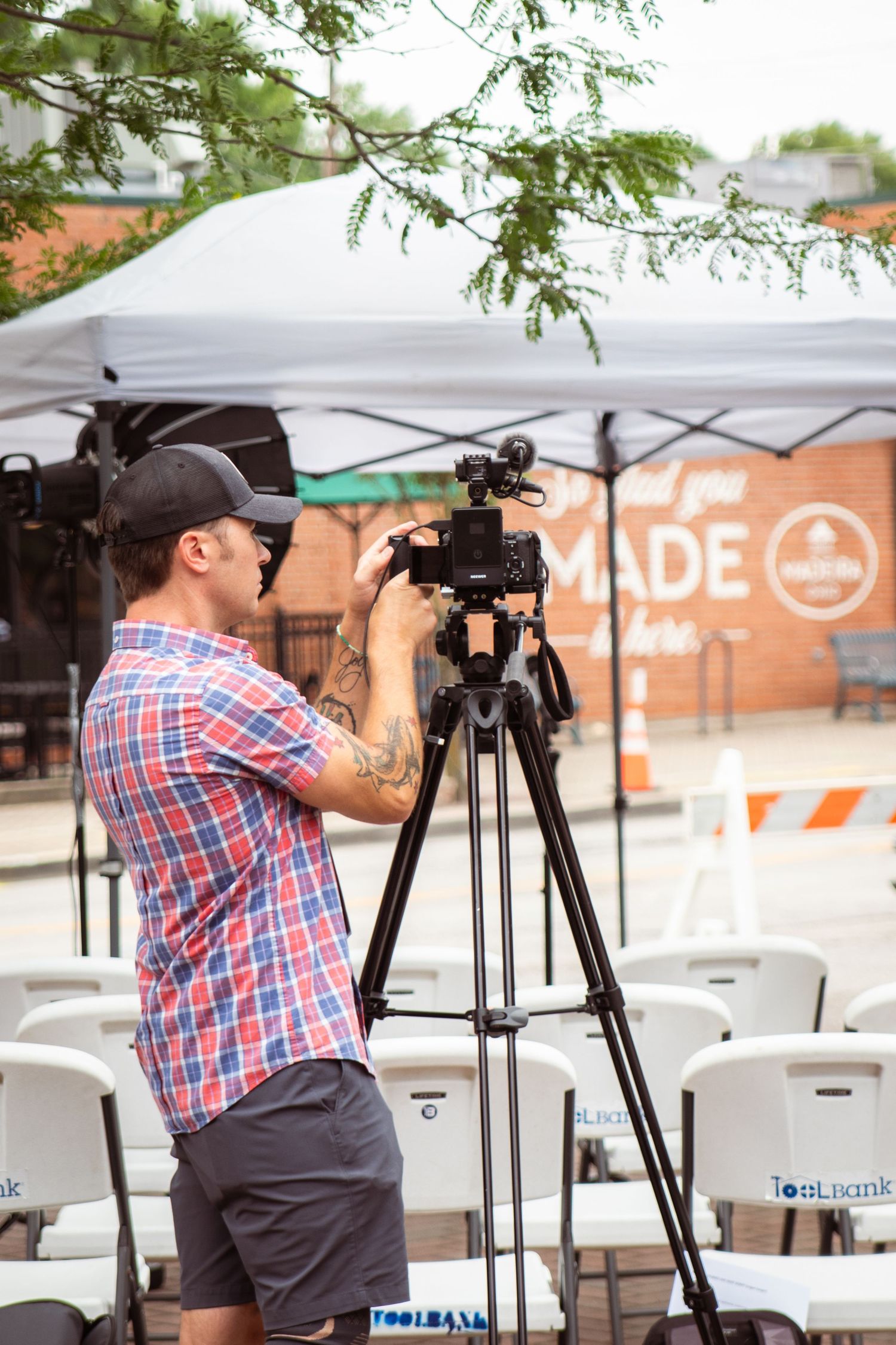 Man standing with camera and tripod setting up equipment for professional branding photos