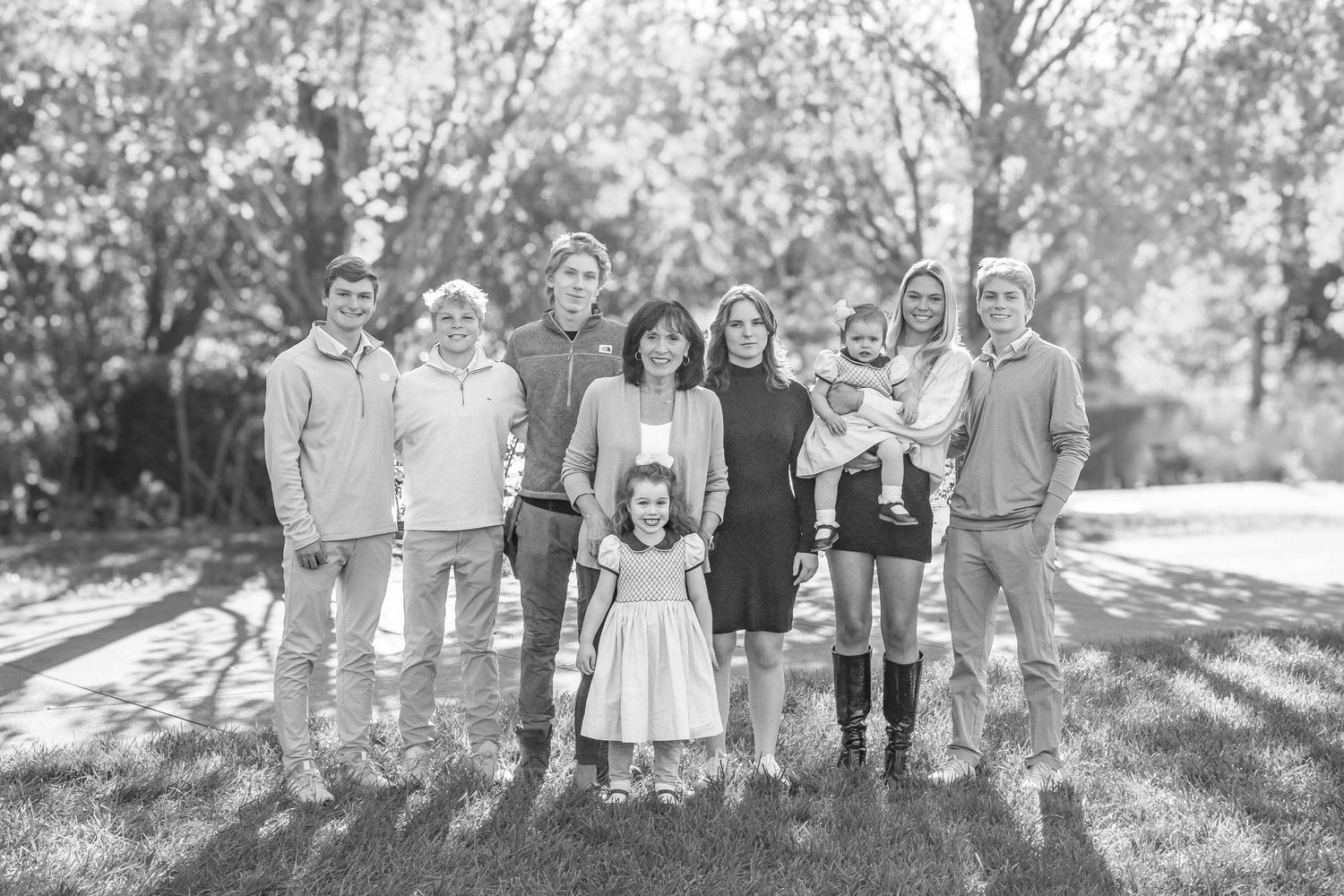 Large family portrait in park of grandma and grandchildren during fall session in black and white