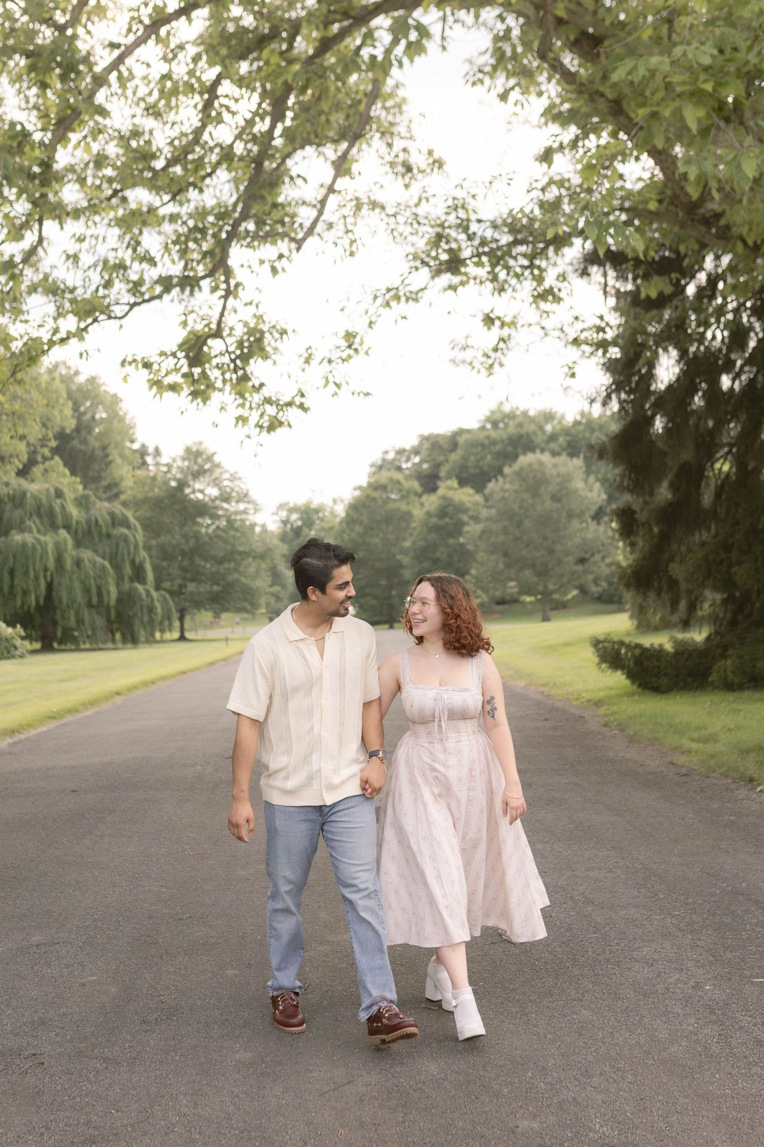 Couple walking together in front of trees at the cemetery