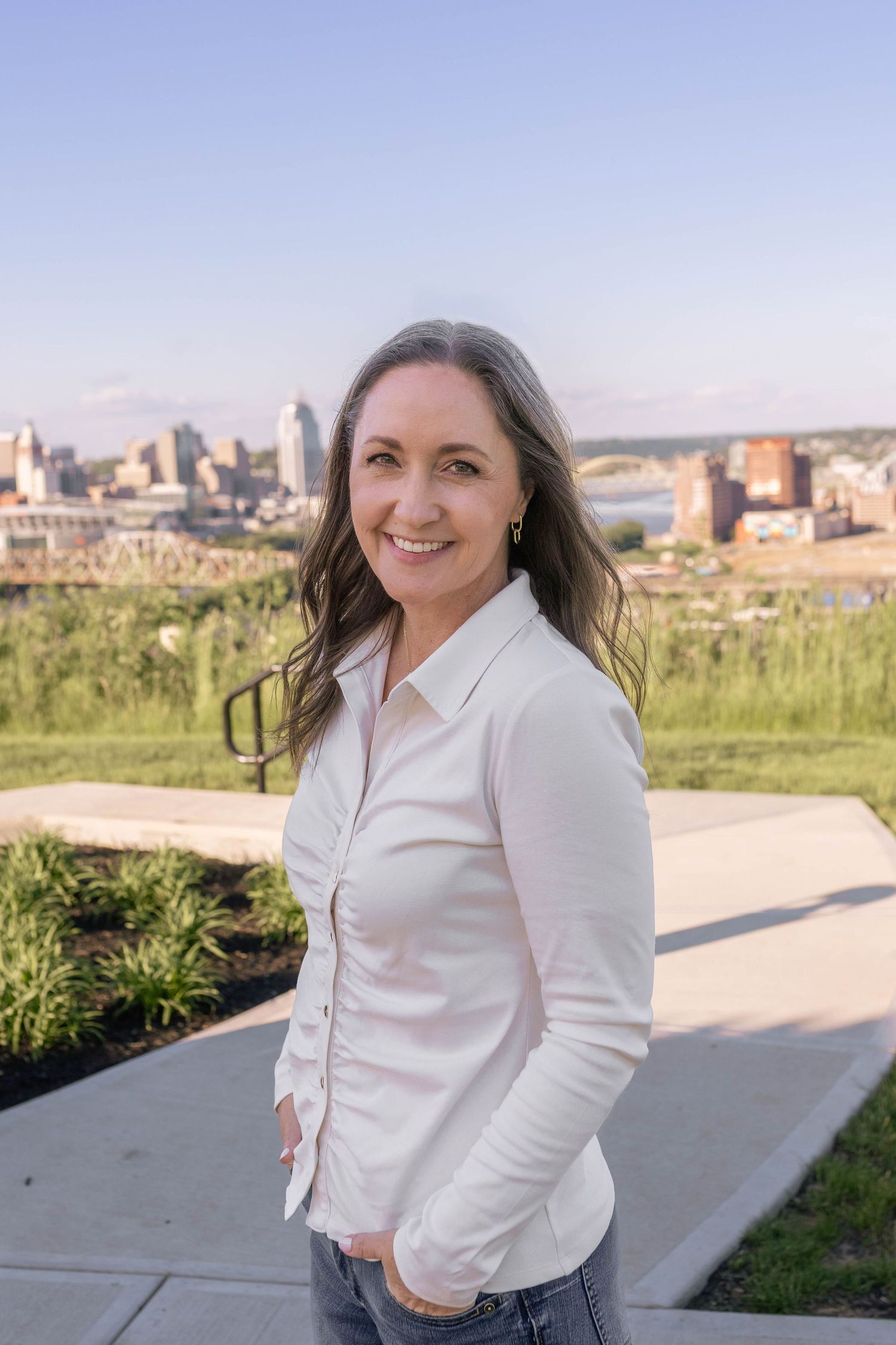 Bright and modern woman business headshot with city skyline