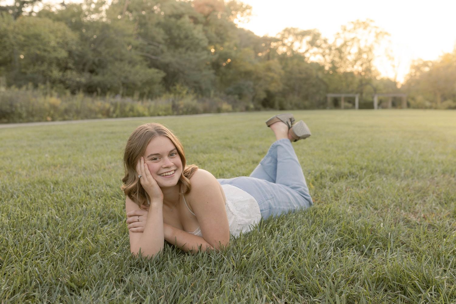 Senior laying on grass in park during sunset