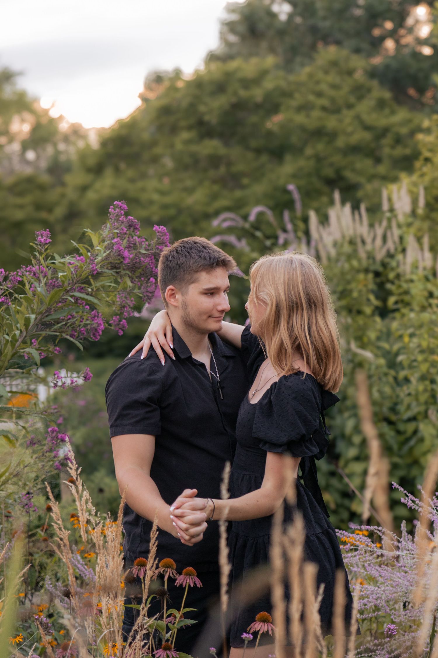 Candid couple photo embracing in flowery park during sunset session