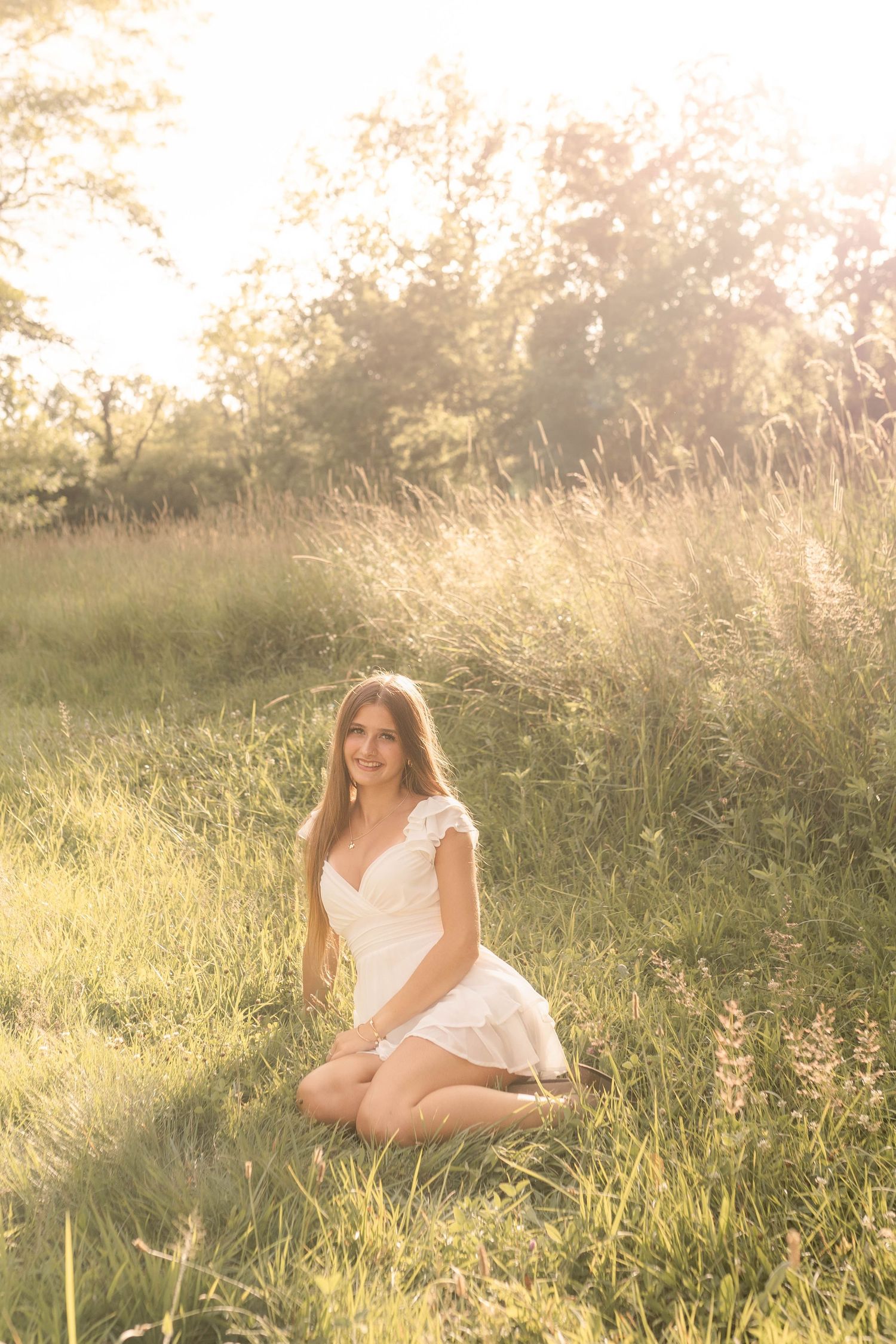 Senior laughing and smiling laying in grassy field during sunset