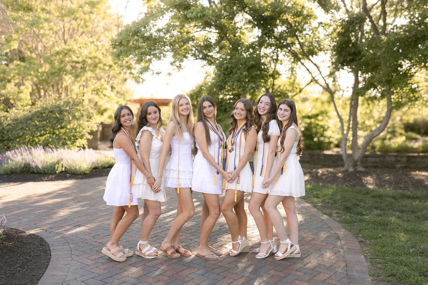 Group of senior girls smiling wearing white dresses