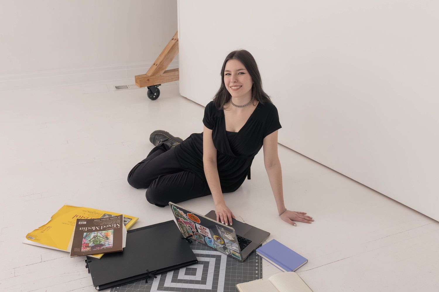 Woman sitting with computer in studio