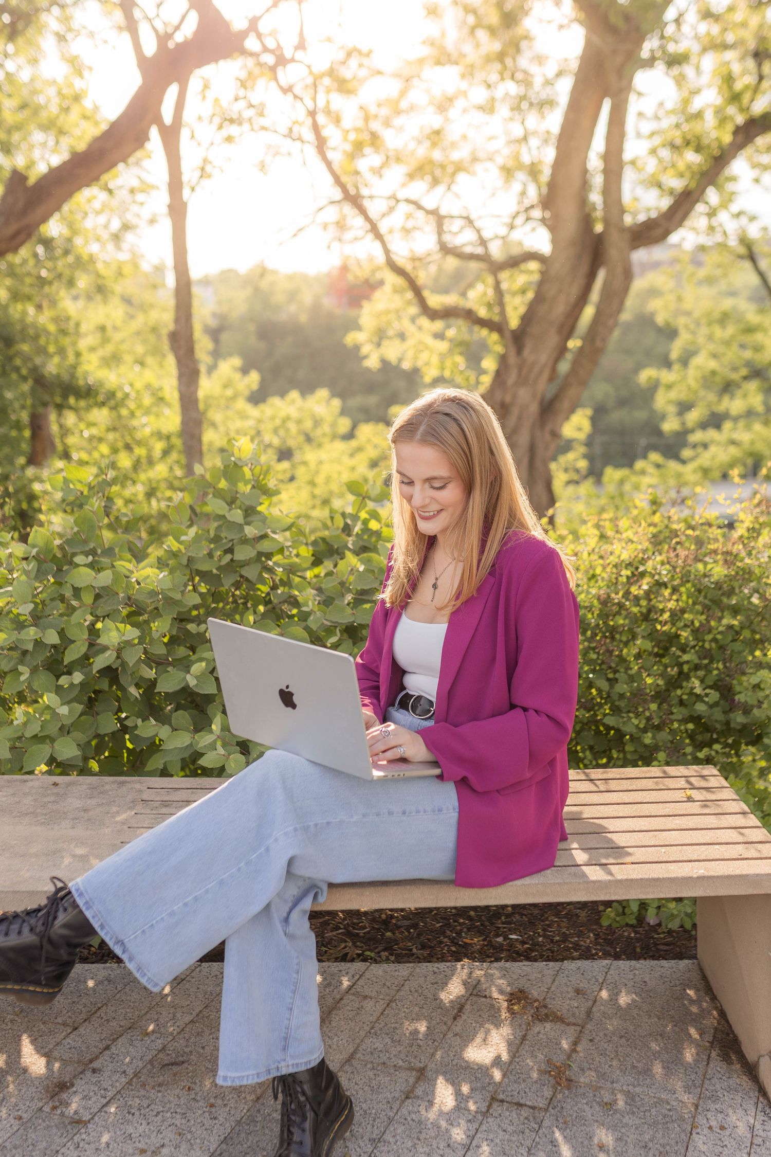 Modern woman branding photo with computer in park-setting during golden hour