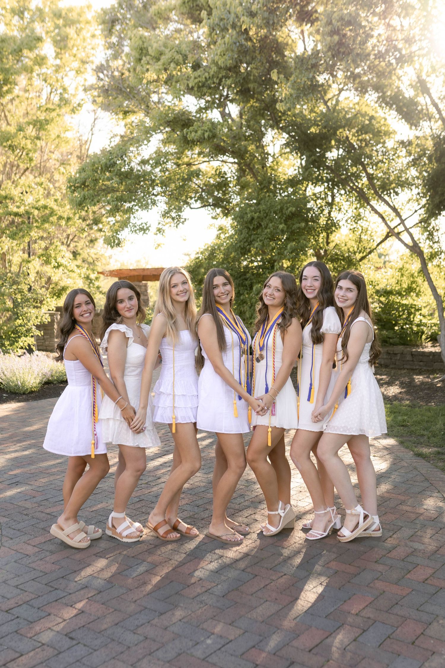 Group of senior girls smiling wearing white dresses