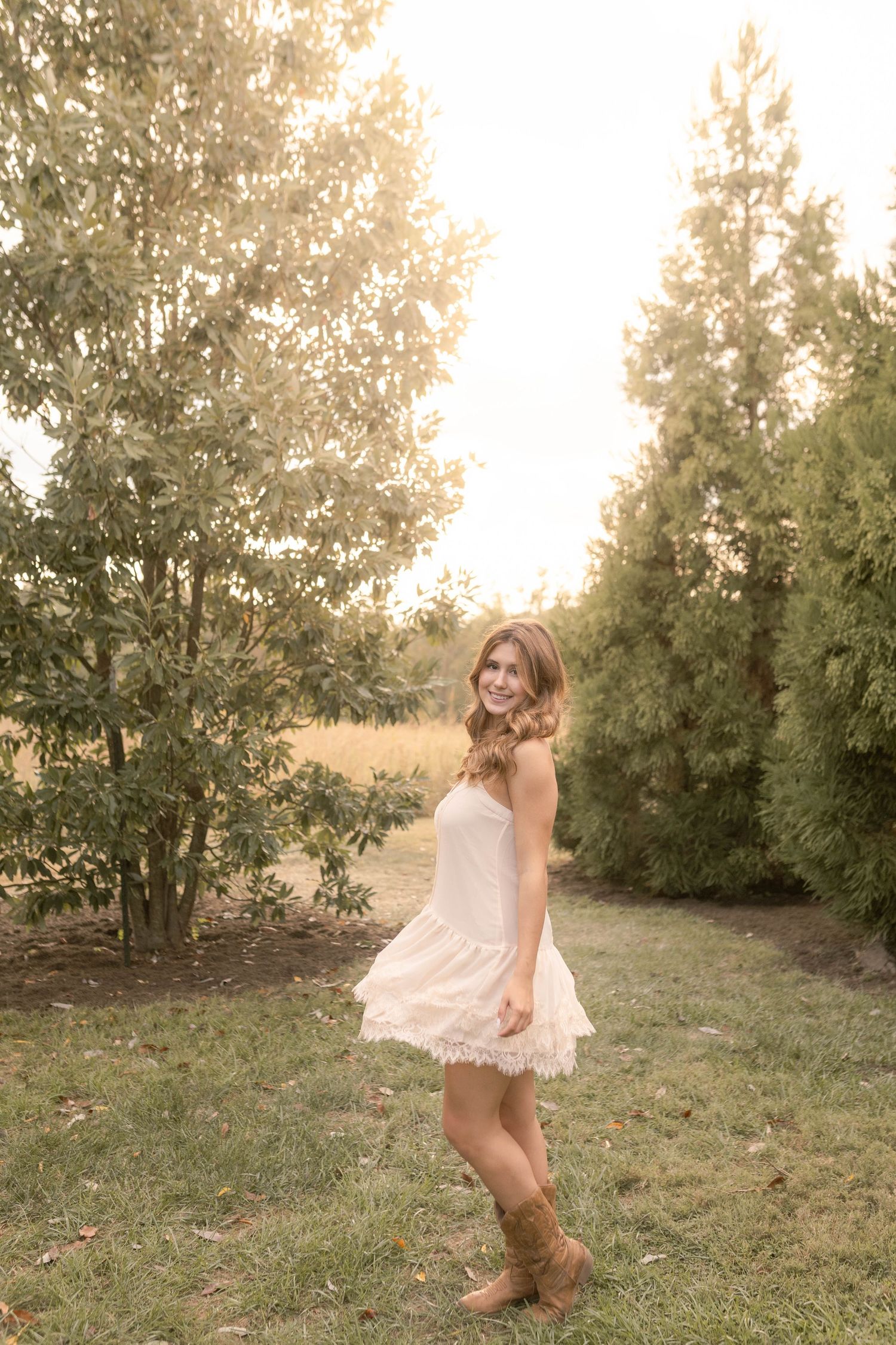 Girl twirling in white dress and cowboy boots during sunset