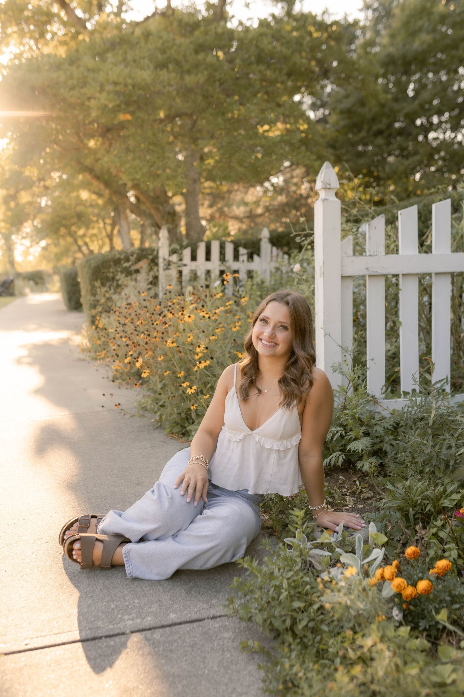 Senior smiling sitting in flowery park during sunset