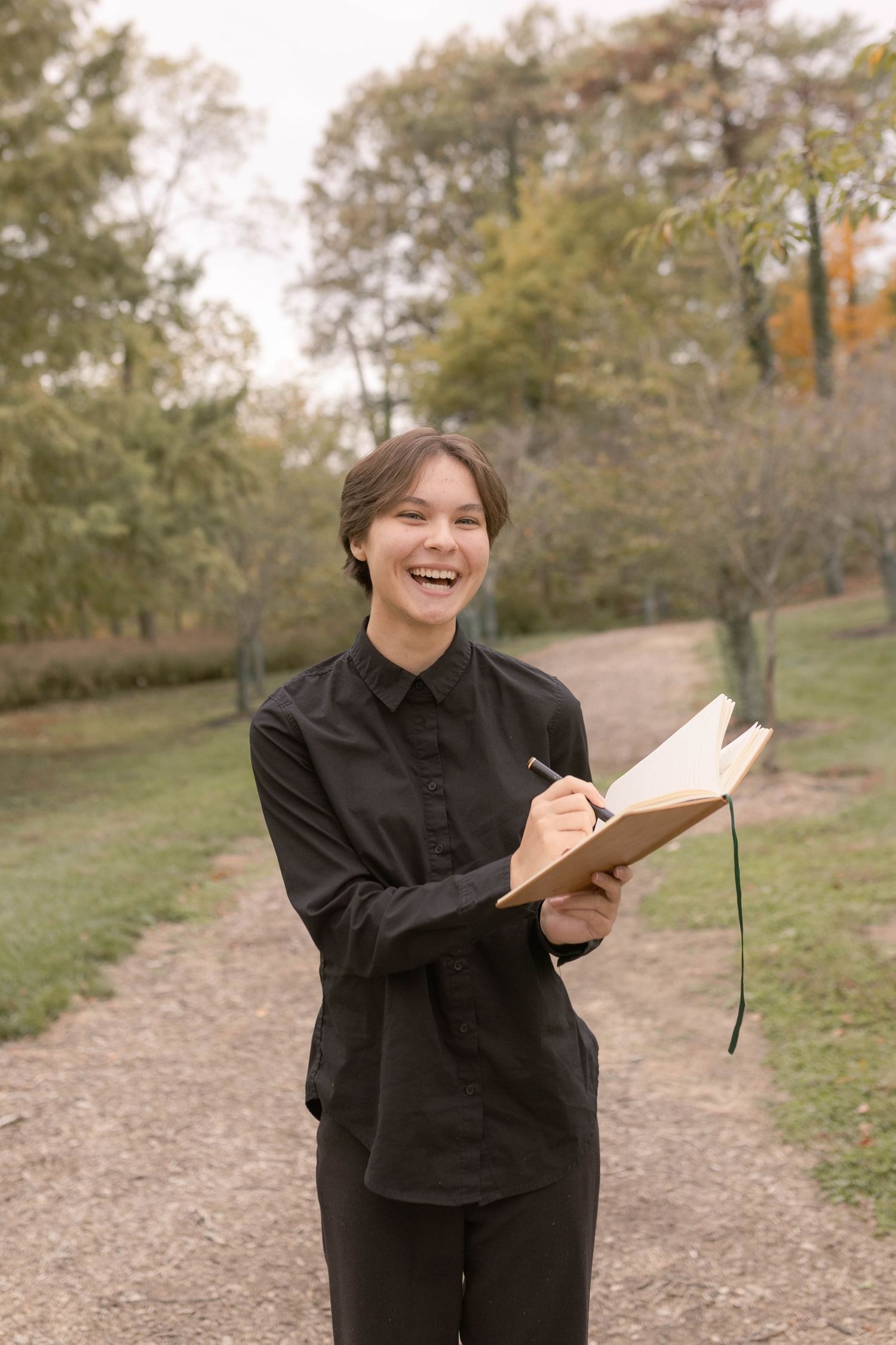 Senior laughing and smiling looking at camera holding sketchbook