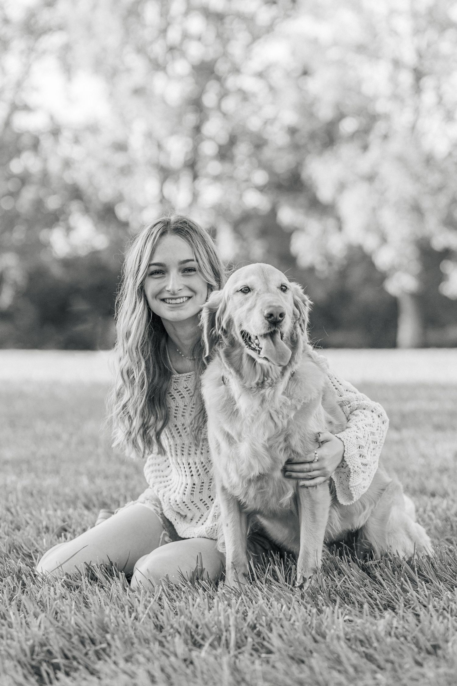 Teen girl with friendly dog at park during senior session in black and white