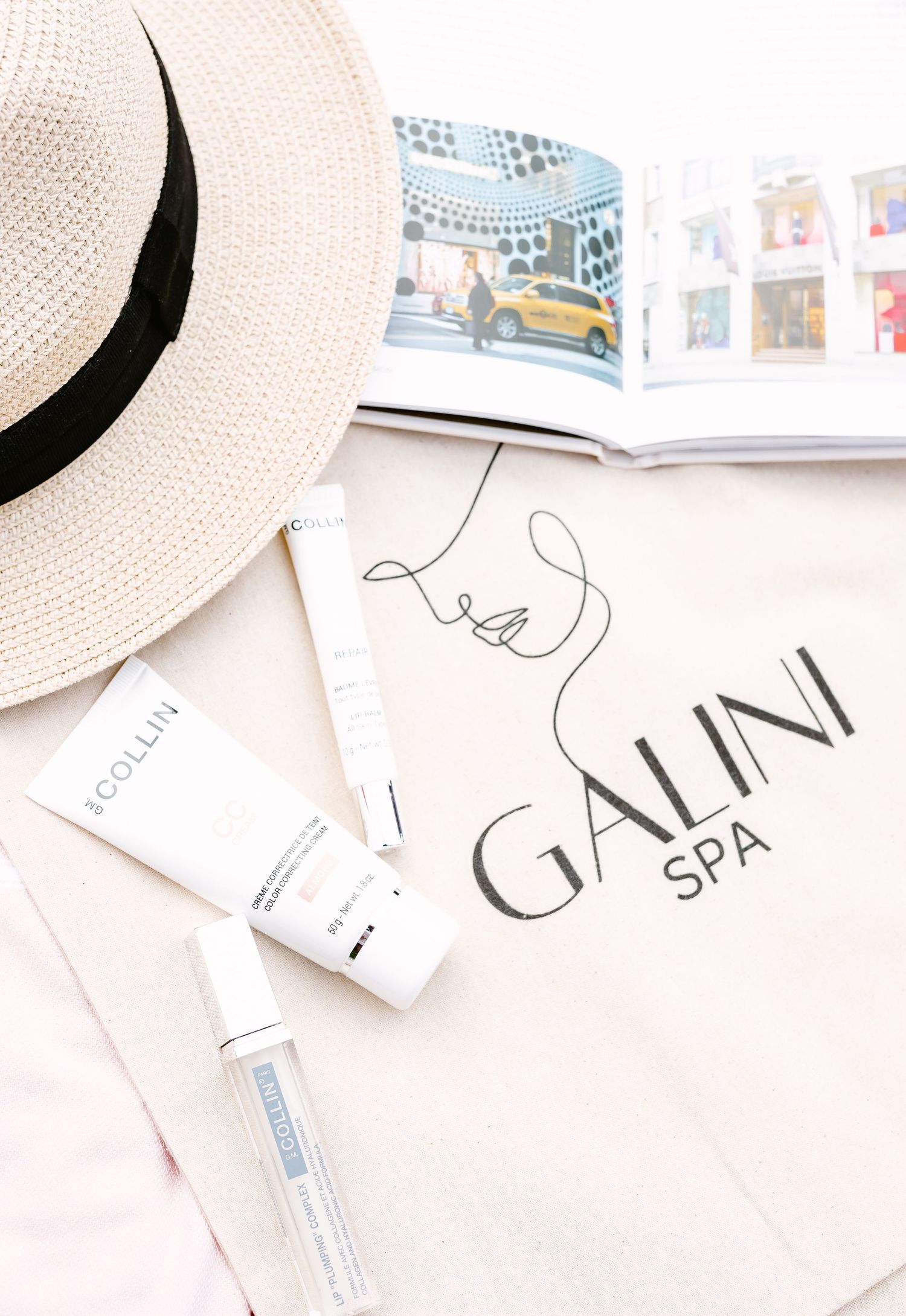 White straw sun hat rests beside paper tags and labels with elegant typography.