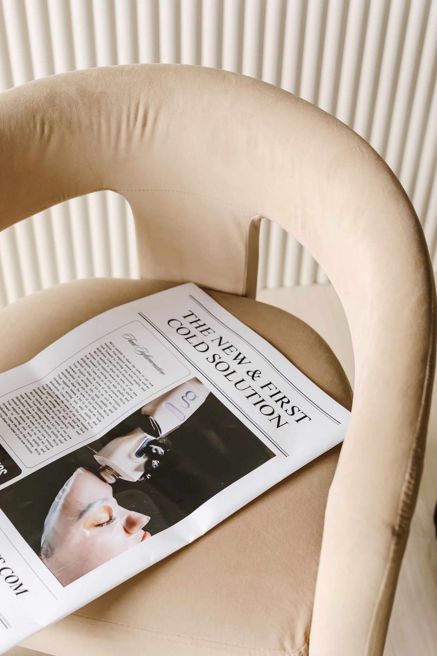 Magazine pages laid flat on cream-colored fabric surface create a visually pleasing composition in neutral tones.
