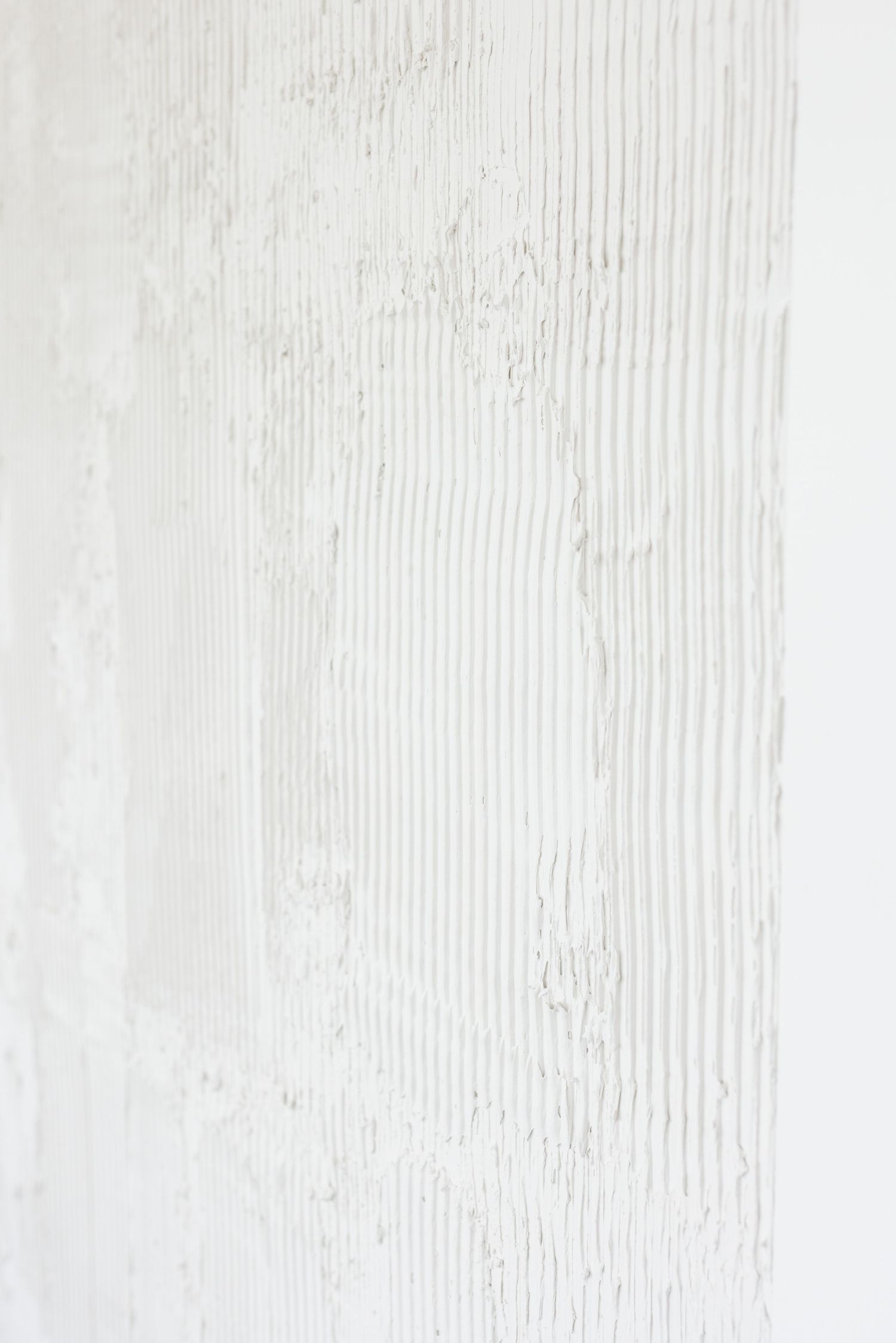 Close-up of white textured wall with vertical striped pattern.