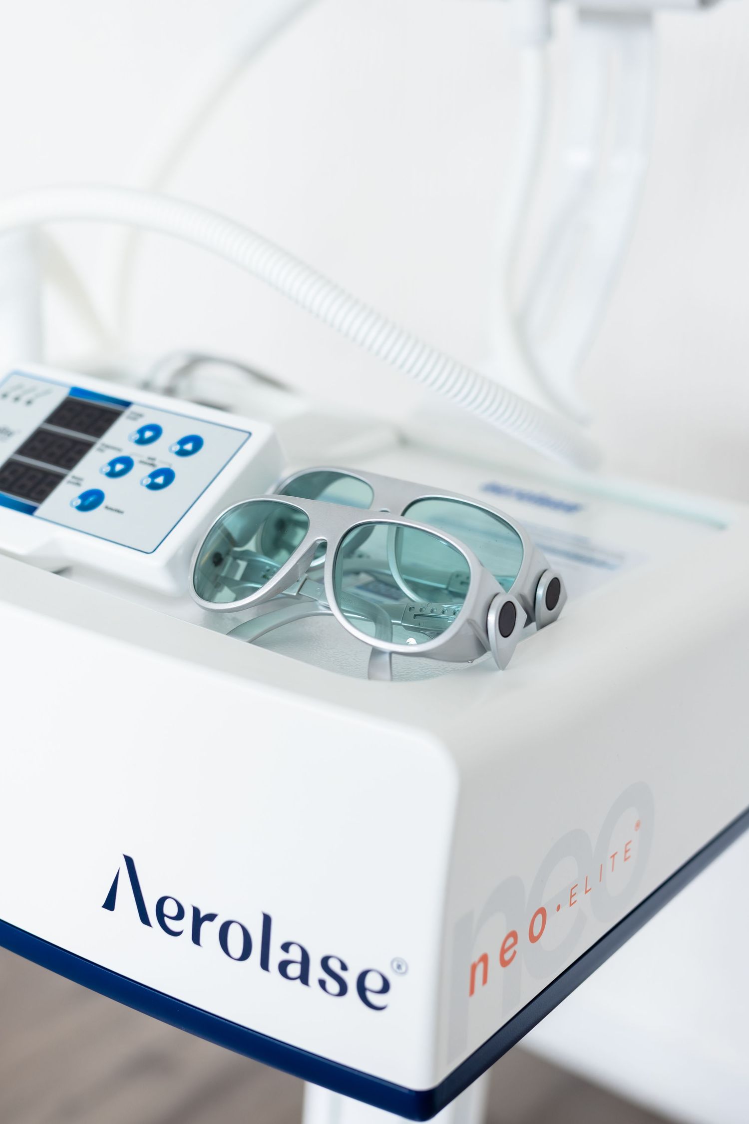 Aerolase NeoElite laser device with protective eyewear on top, used for advanced skin treatment in medical aesthetics.