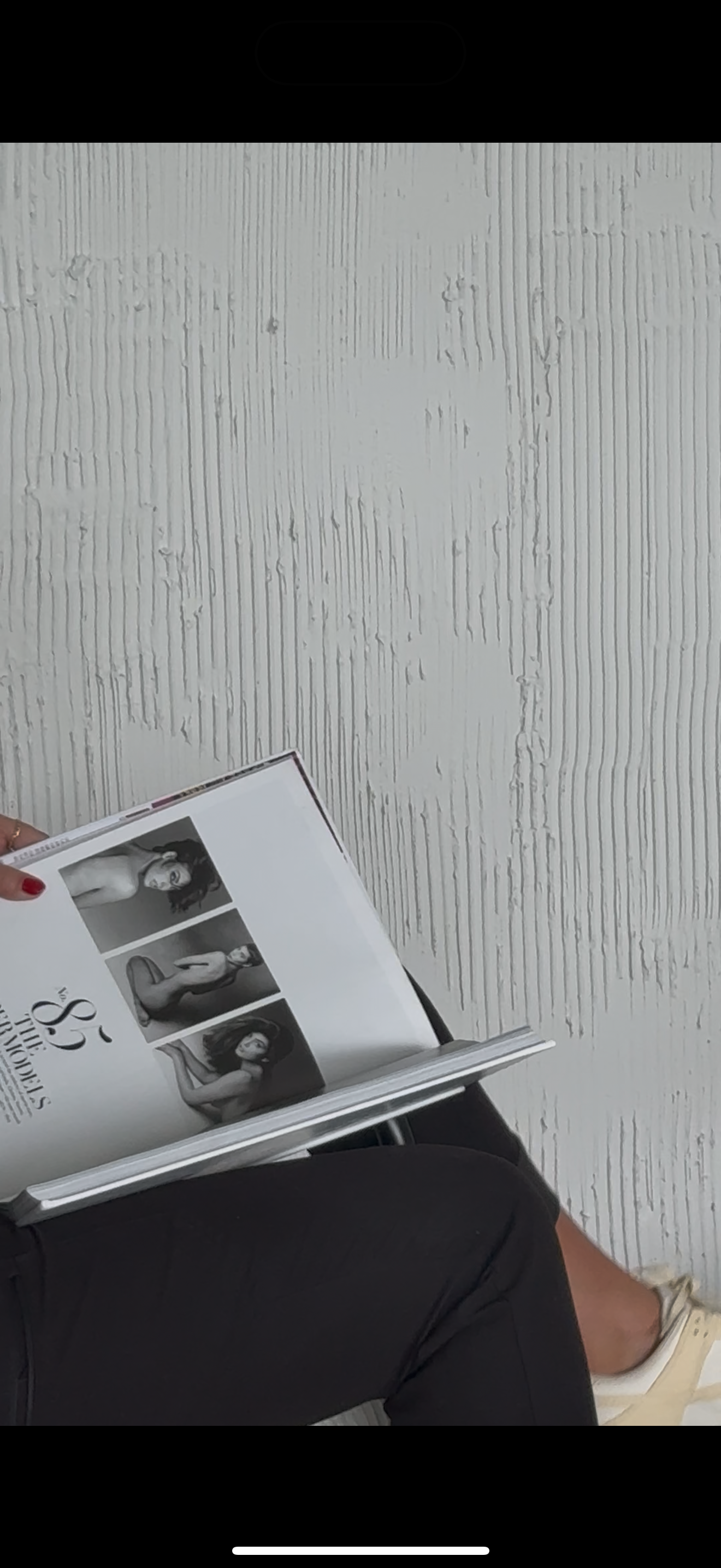 Behind-the-scenes view of someone looking through a photography portfolio or magazine.
