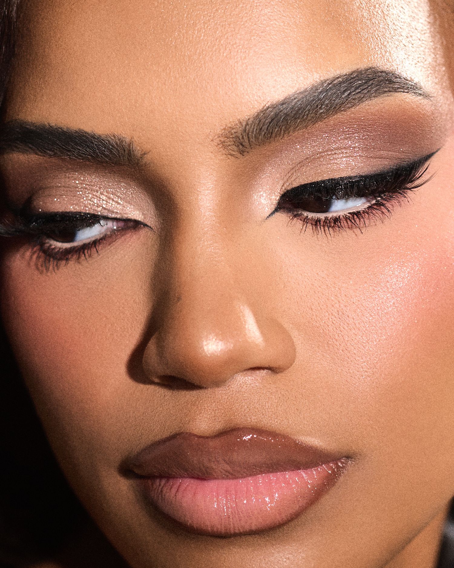 Close-up beauty shots showcase flawless makeup with winged eyeliner and nude lipstick on dark skin.
