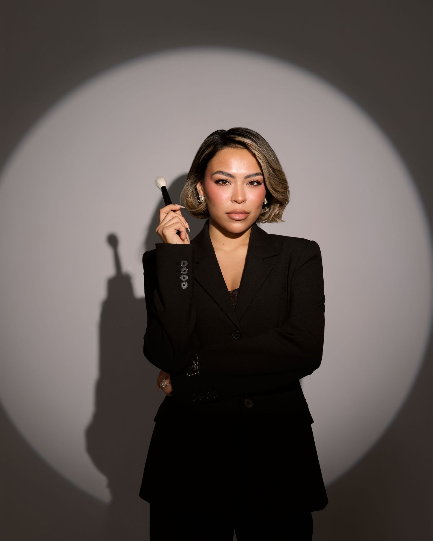 Professional studio portraits in black attire against a dramatic gray background with shadow effects.