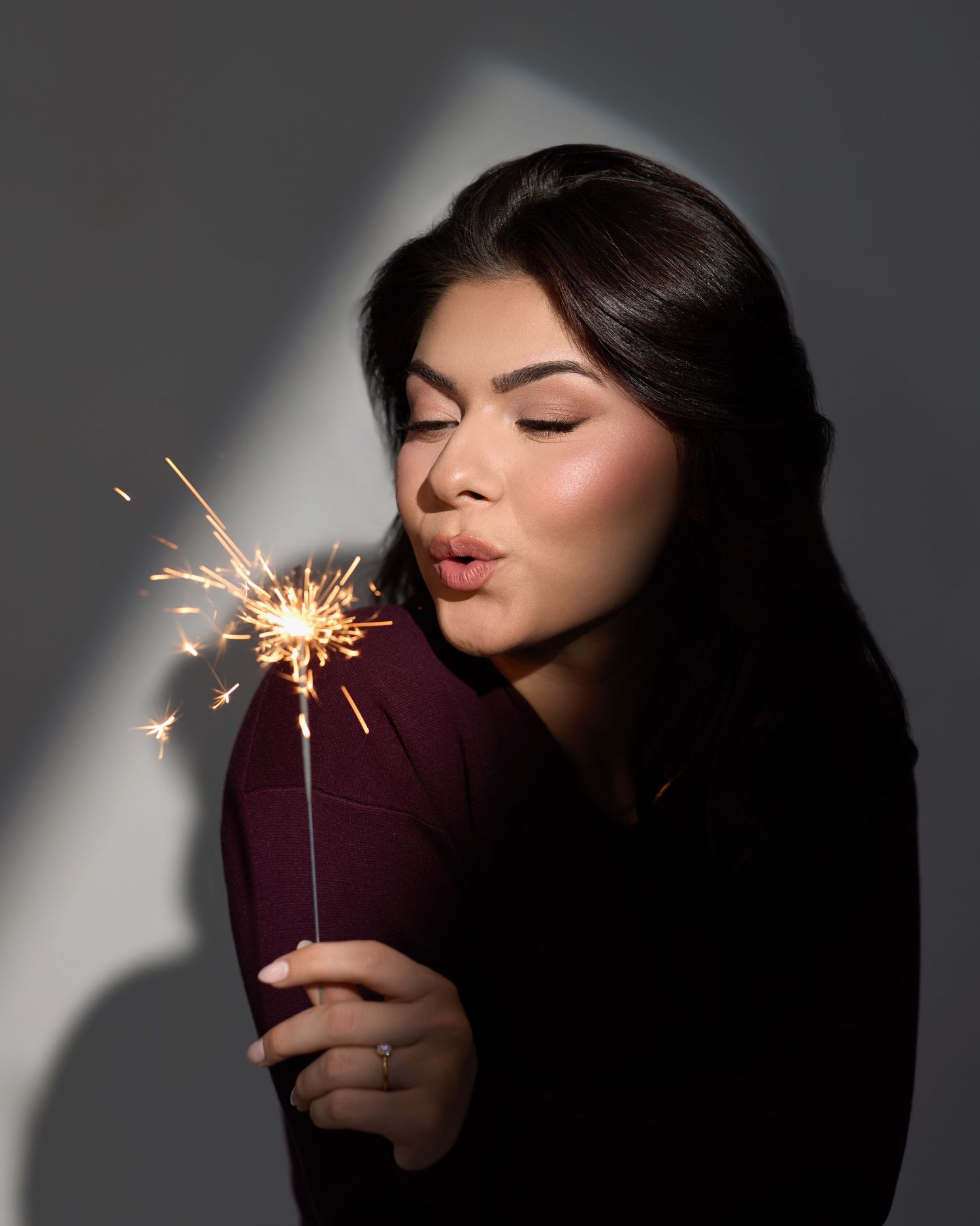 A sparkler creates magical light trails against a dark background in a series of artistic photos.
