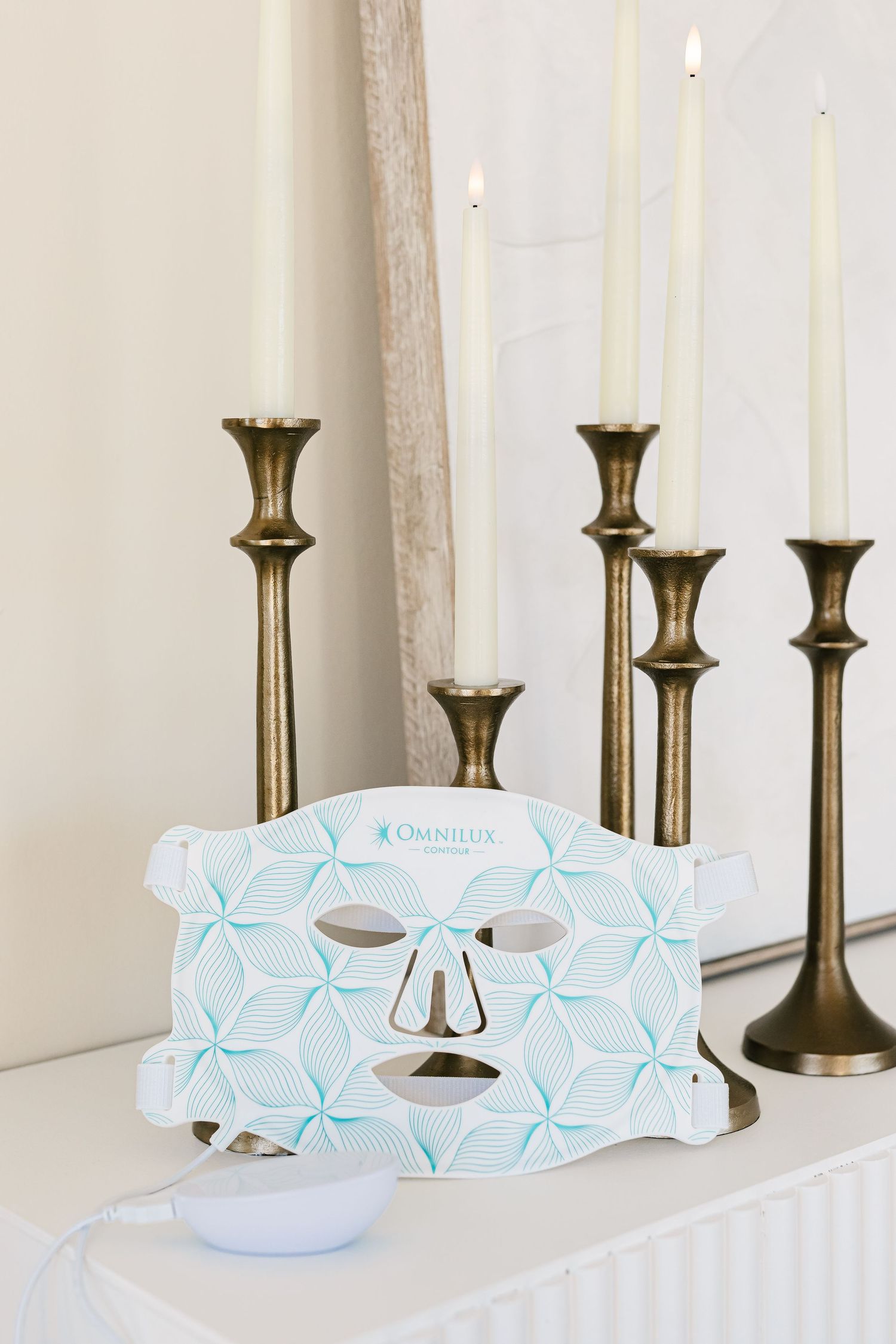 Brass candle holders stand elegantly on a white surface with light blue tissue boxes arranged in a row.