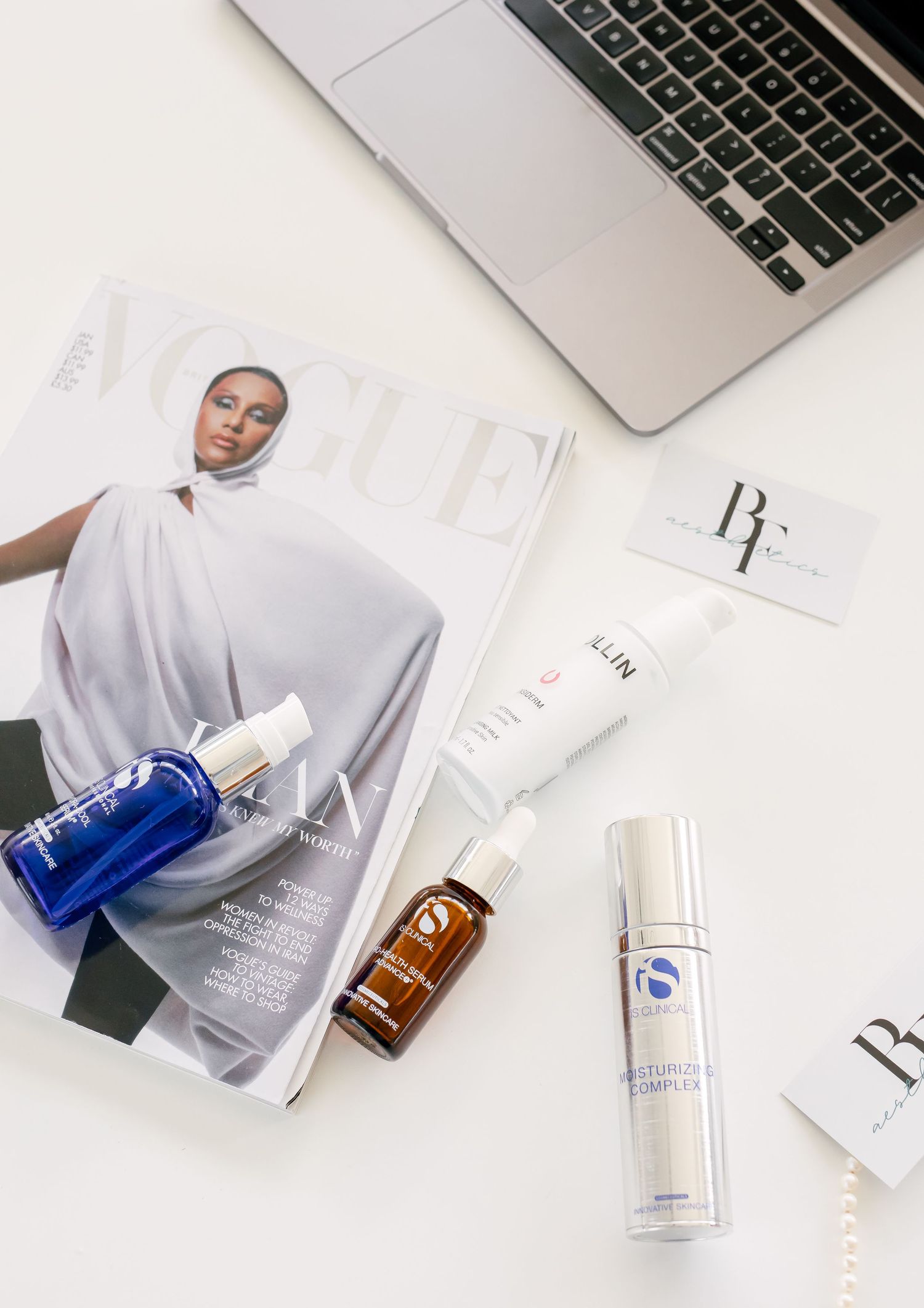 White clean desk layout with skincare products, laptop, and beauty essentials arranged in minimal aesthetic style.
