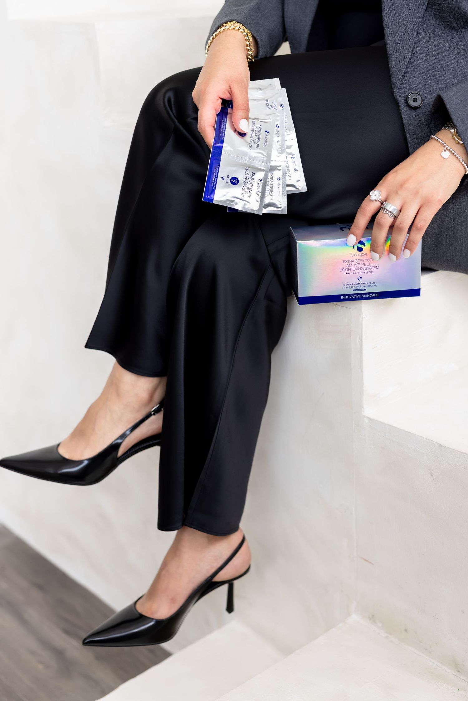 Professional woman in black office attire holds a document while wearing pointed slingback heels.
