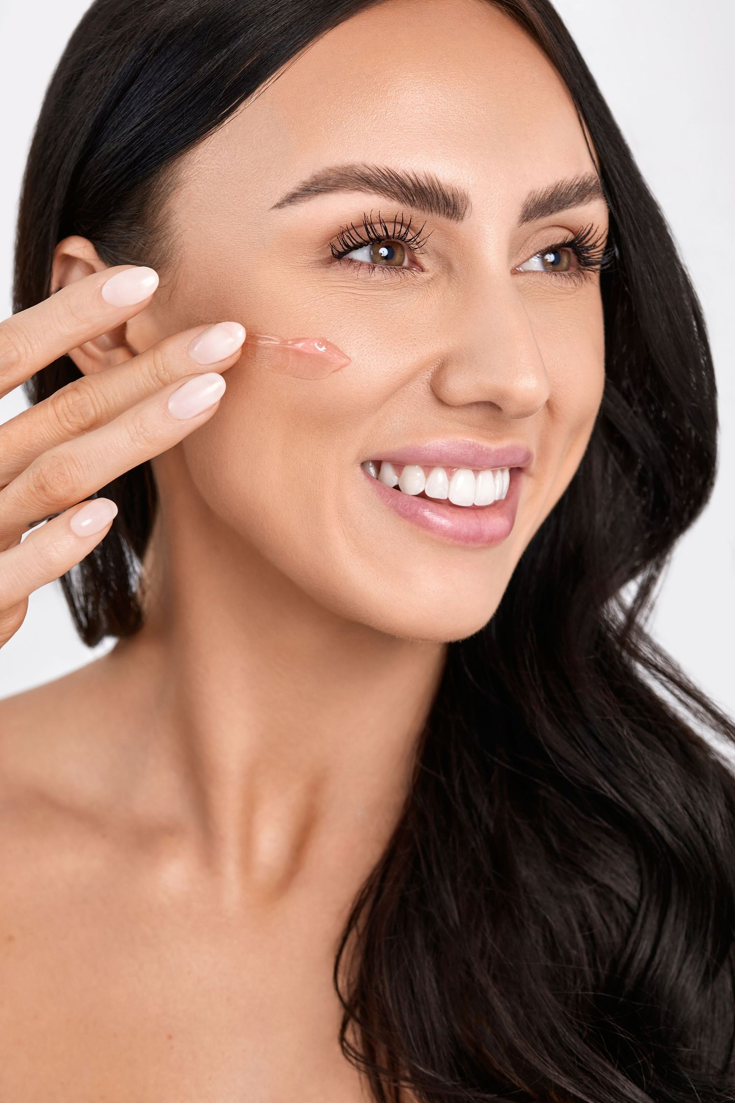Beauty close-up shot showing glowing skin and natural makeup with peace sign gesture.