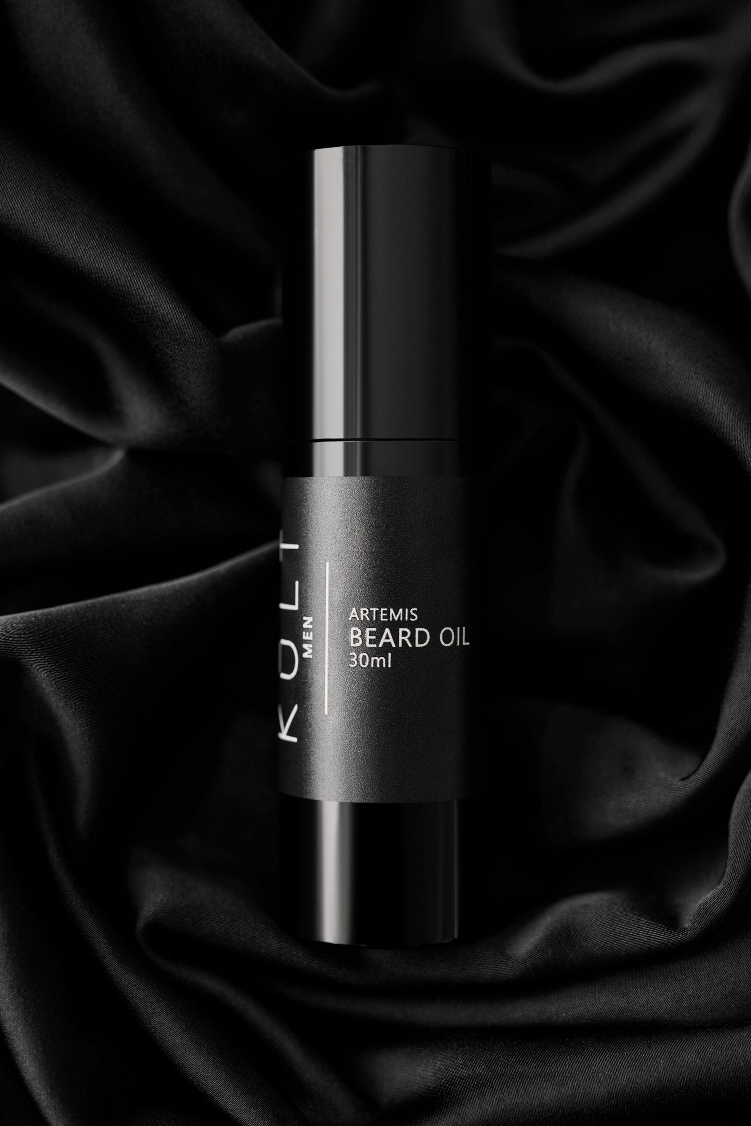 Sleek black beard oil bottles with minimalist design displayed on dark silk fabric background.