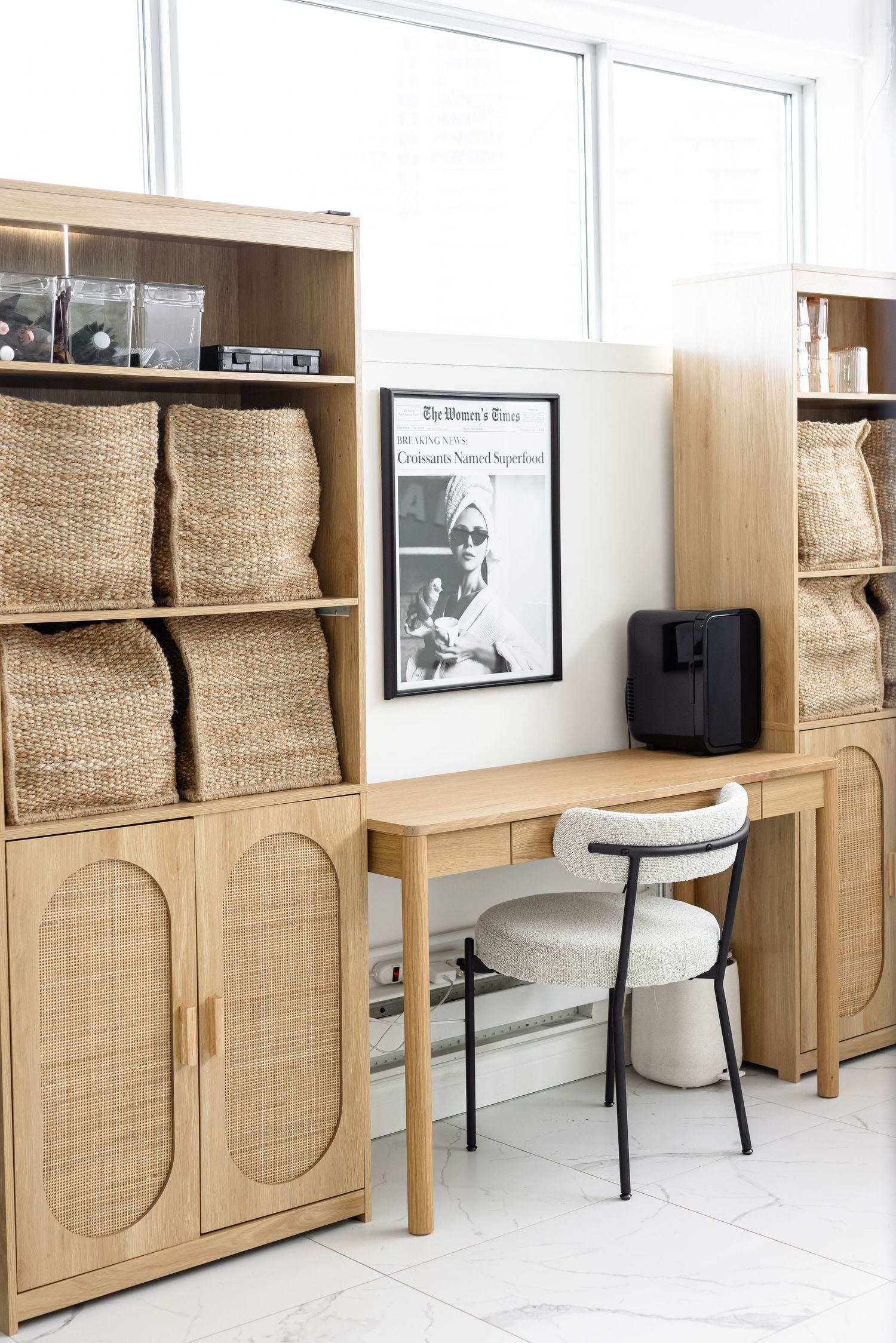 Modern office storage area with wooden cabinets, wicker baskets, and white chairs along a clean white wall.