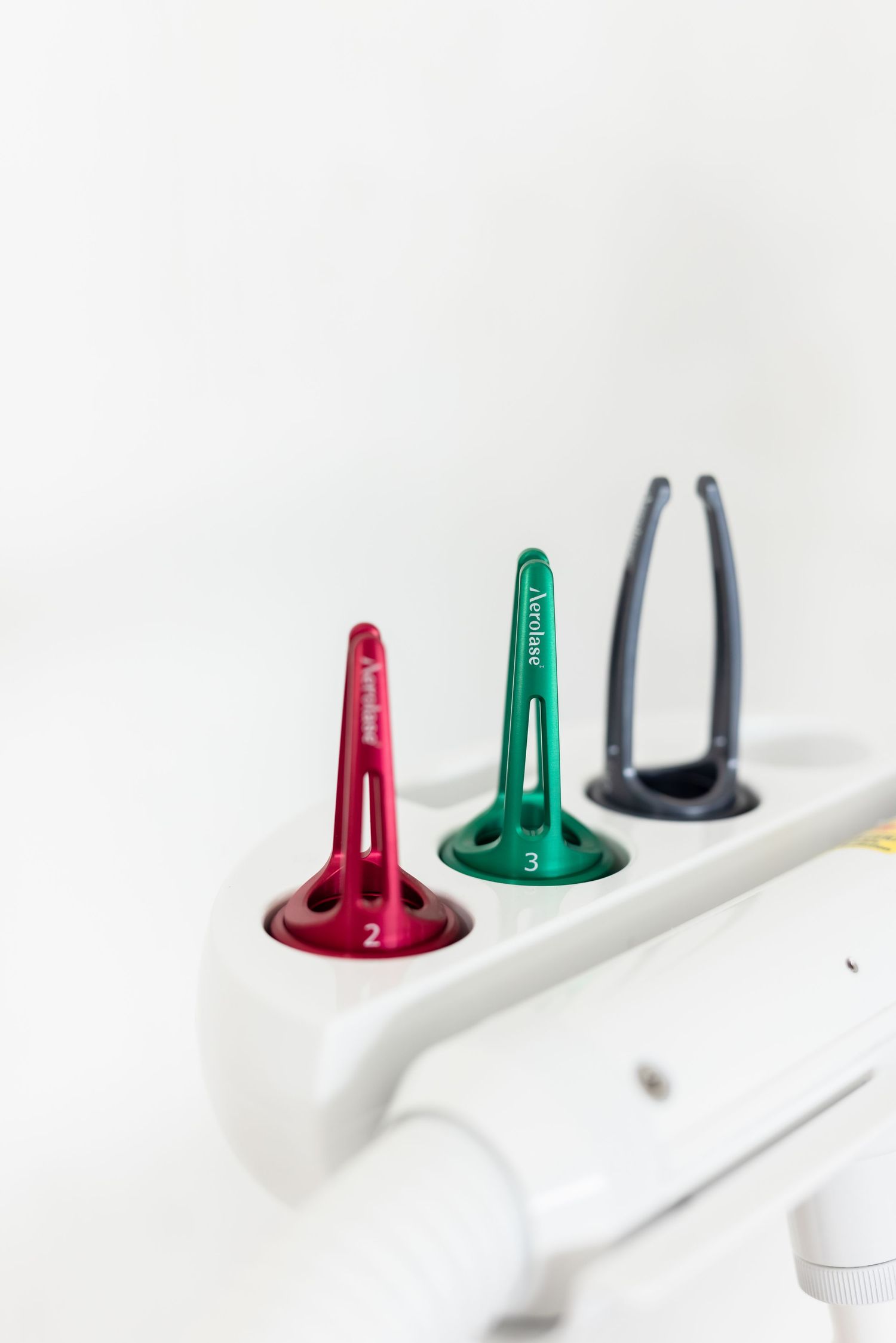 Closeup view of colorful red and green electrical power outlet sockets against a white background.