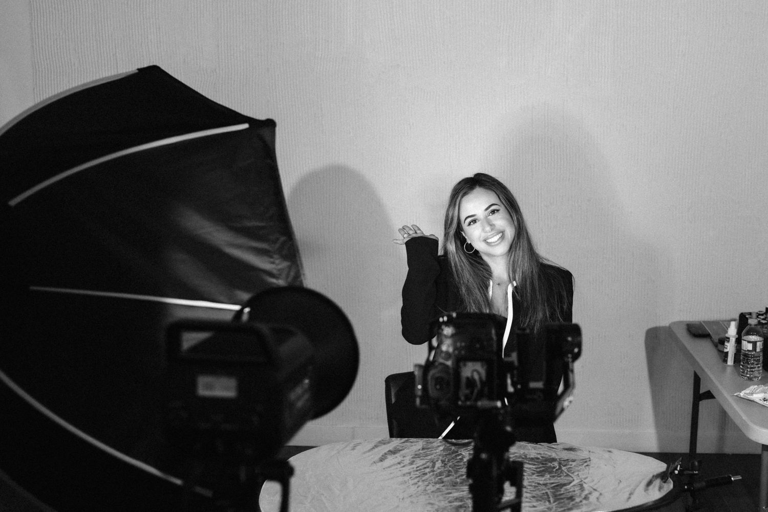 Black and white behind the scenes photography studio equipment setup with lighting gear and reflectors.