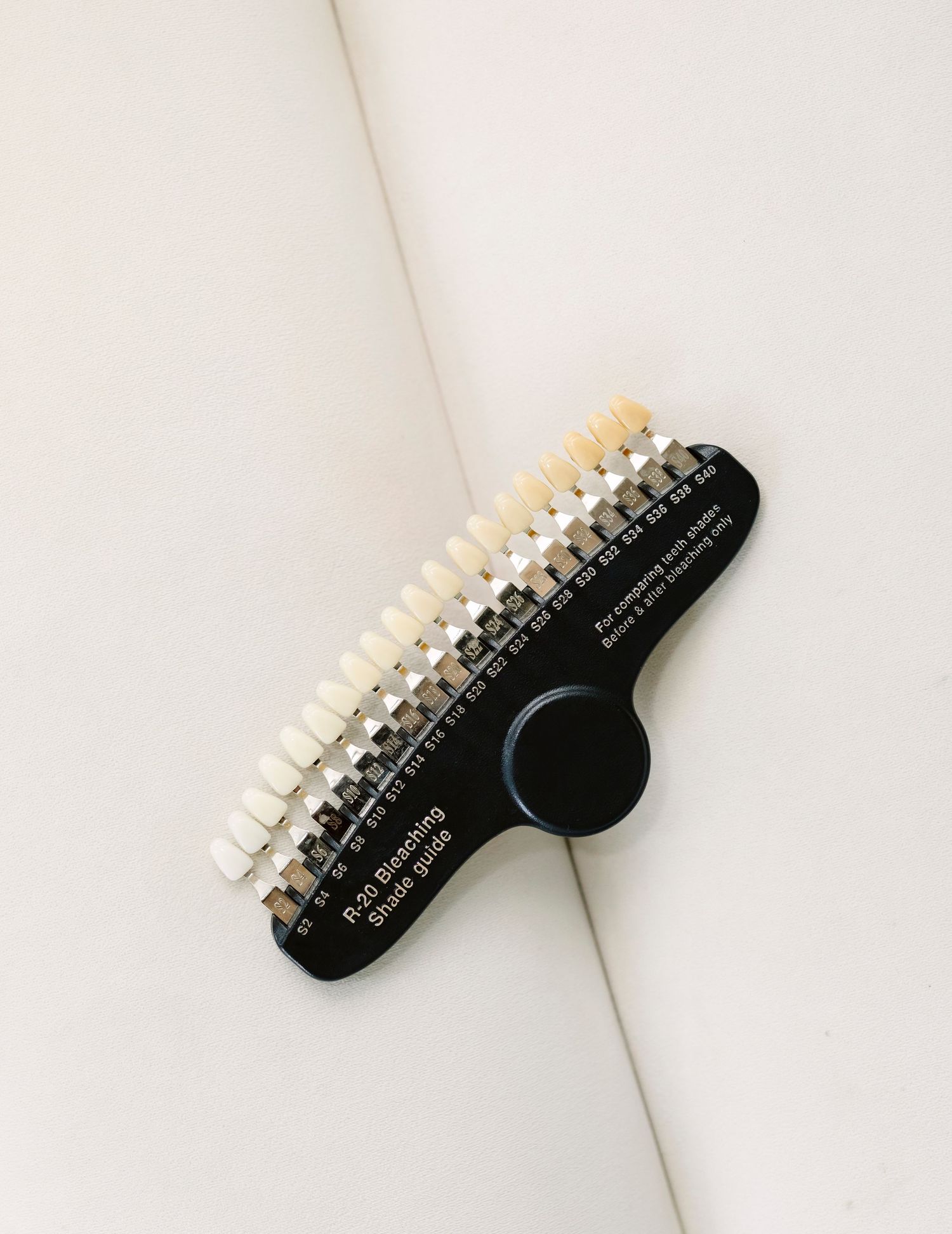 White bristle brush with black handle rotates shown in four different positions against light background.
