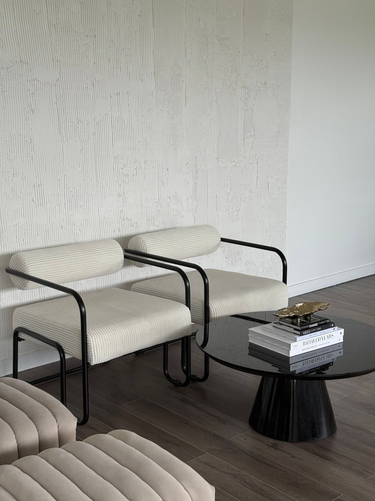 Modern studio lounge area with curved black furniture and minimalist decor.