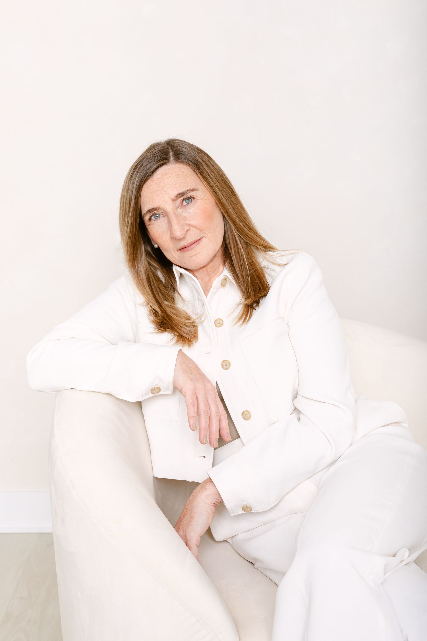 Professional portrait series showing person in white button-up jacket against light background in various poses.