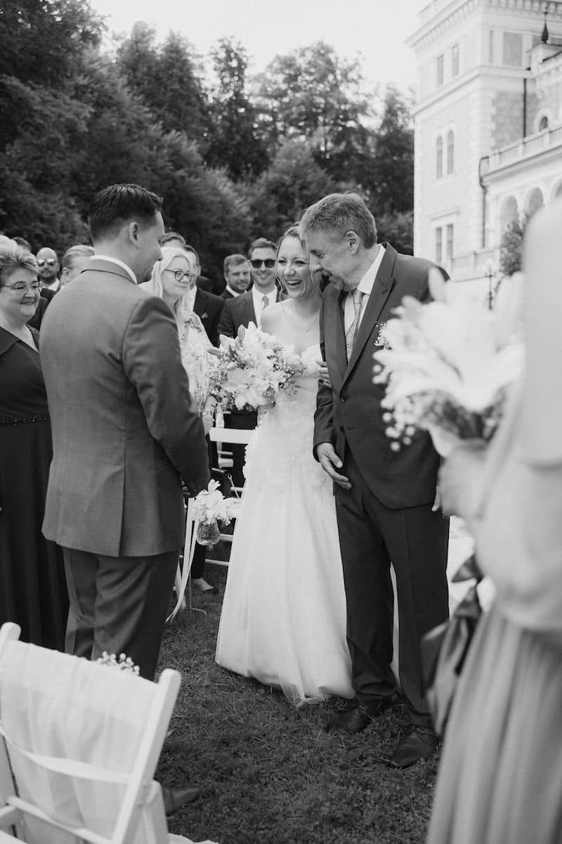 Lauren geht mit ihrem Papa zum Altar auf ihren Bräutigam zu. Beide Männer sehen sie an, sie strahlt