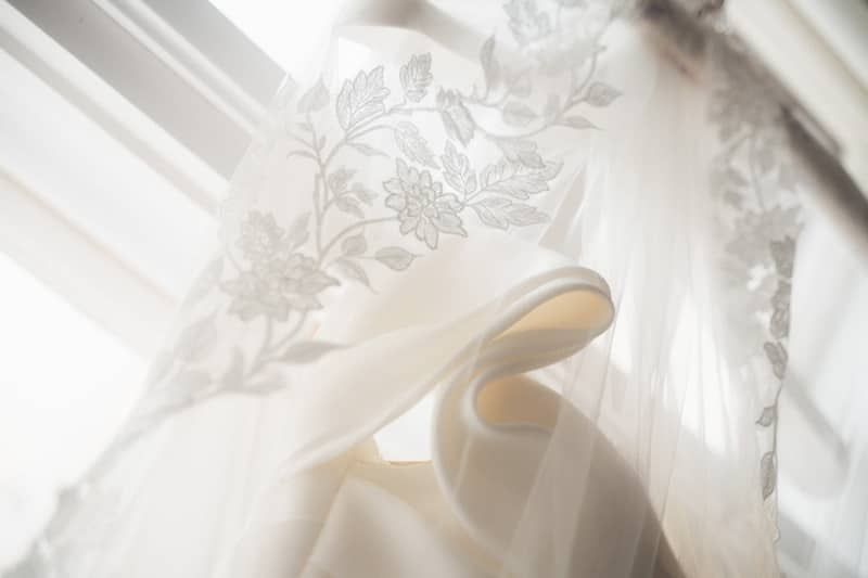 Details des Brautkleides. Es hängt vor einem Fenster.